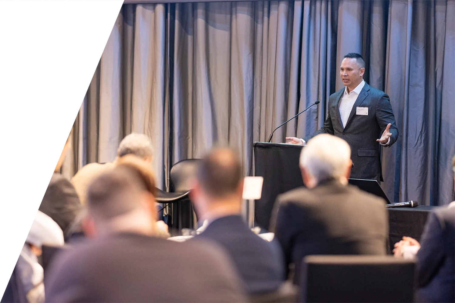 A man in a business suit giving a presentation at a Weave Leadership event