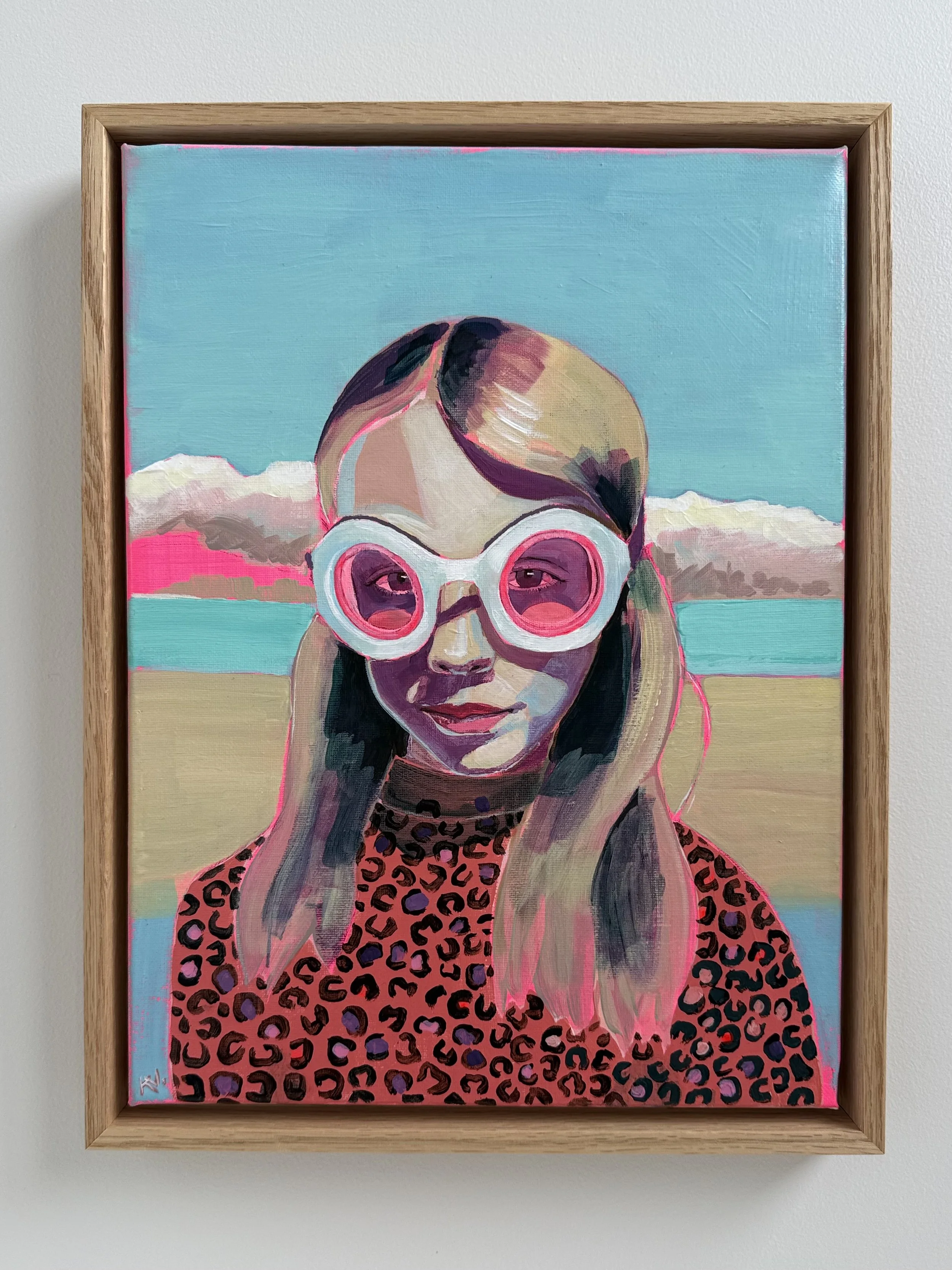 Portrait of Ava age 5, wearing flying goggles and a leopard print rash shirt.