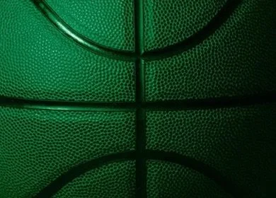 Close-up of a green basketball showing the textured surface and black lines