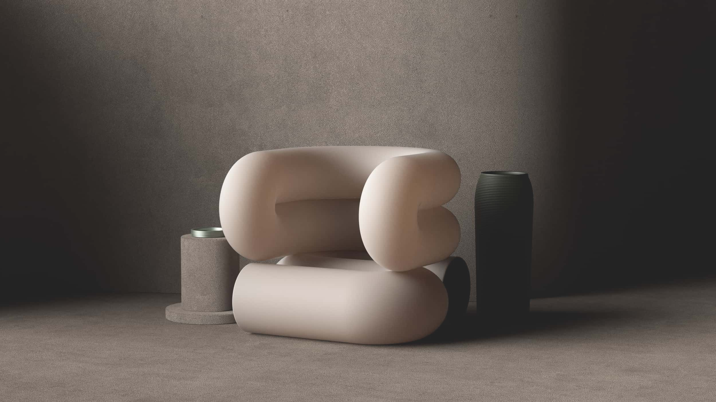 Minimalist arrangement of abstract sculptural objects on a neutral-toned surface. Large beige and white rounded forms, a small cylindrical black vase, and a small round container with a lid.