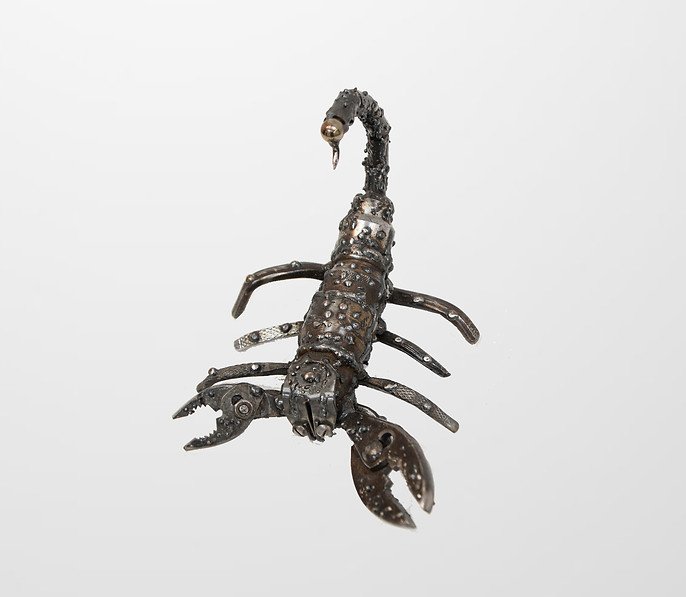 Metal scorpion sculpture made from mechanical parts on white background