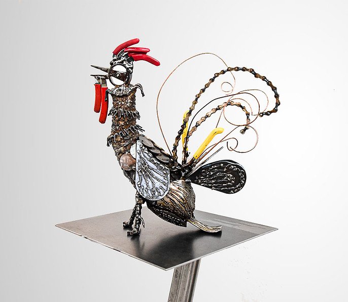 Metal rooster sculpture with intricate design on a stand