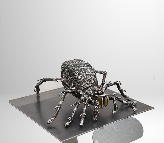 Metal sculpture of a spider on a metallic platform