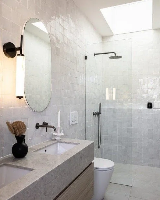 Soft, light-filled ensuite goals

The glossy handmade zellige tiles are doing all the heavy lifting here with the subtle variation and sheen reflecting the daylight pouring in from the skylight.

Paired with a custom stone vanity with a chunky waterf