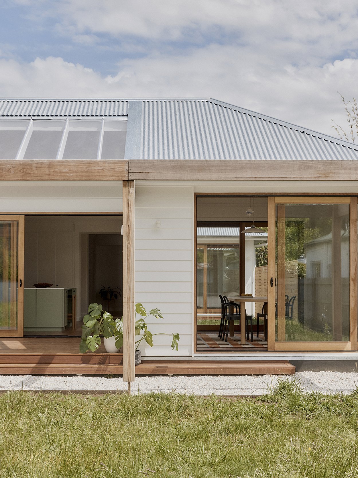 Rear elevation of Mittagong Courtyard Cottage with timber-framed posts, skylight and kitchen visible through sliding doors