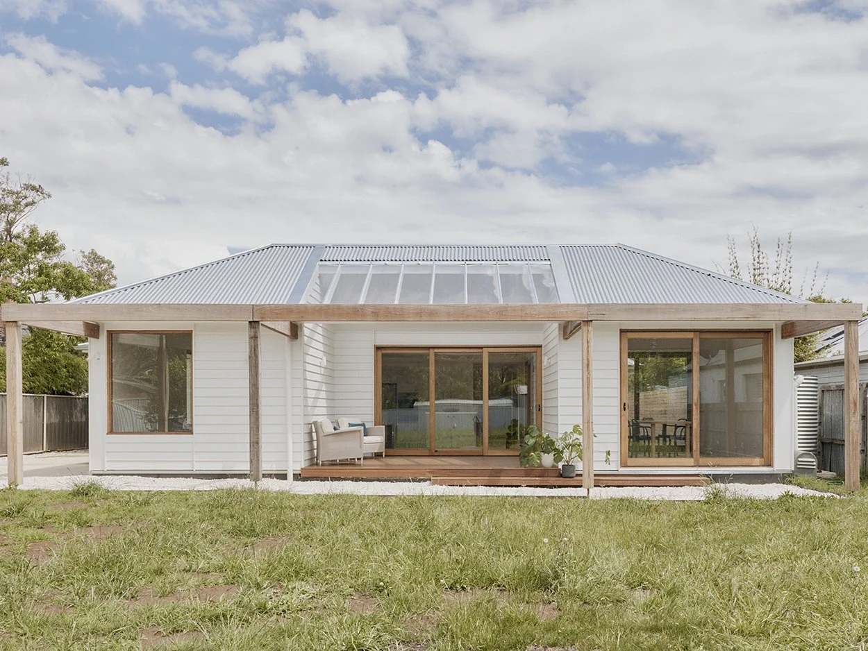Full rear elevation of Mittagong Courtyard Cottage showing skylight roof feature, timber deck and north-facing garden