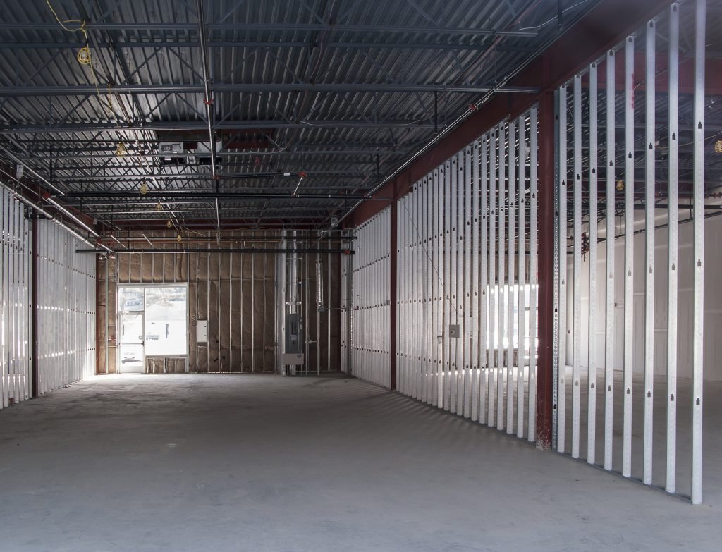 Interior of a building under construction with metal framing and exposed ceiling.
