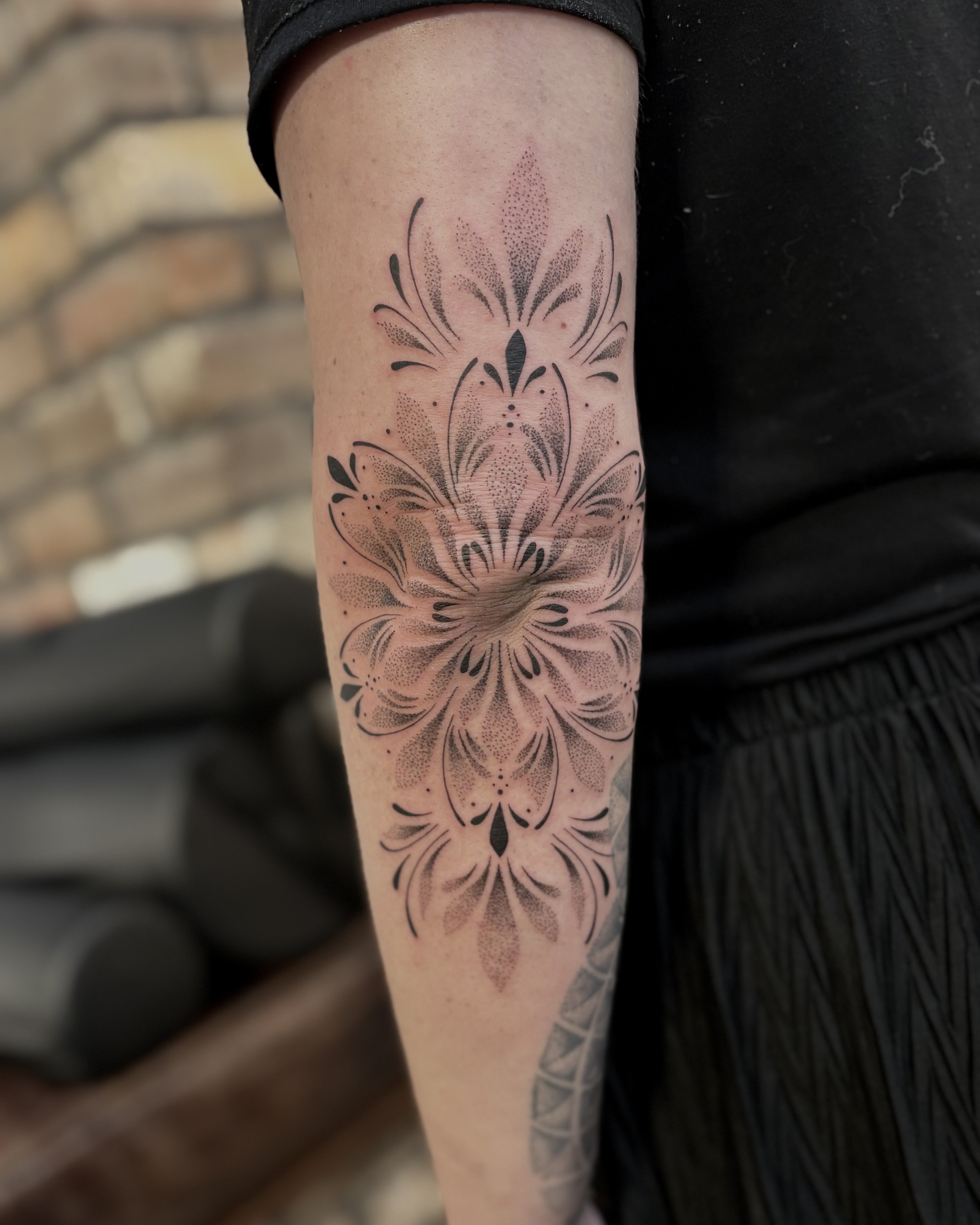 Dotwork mandala tattoo by Soleya Tattoo in Auckland —  featuring an intricate mandala centerpiece and dotwork detailing. A powerful and symmetrical elbow piece blending precision and pattern.