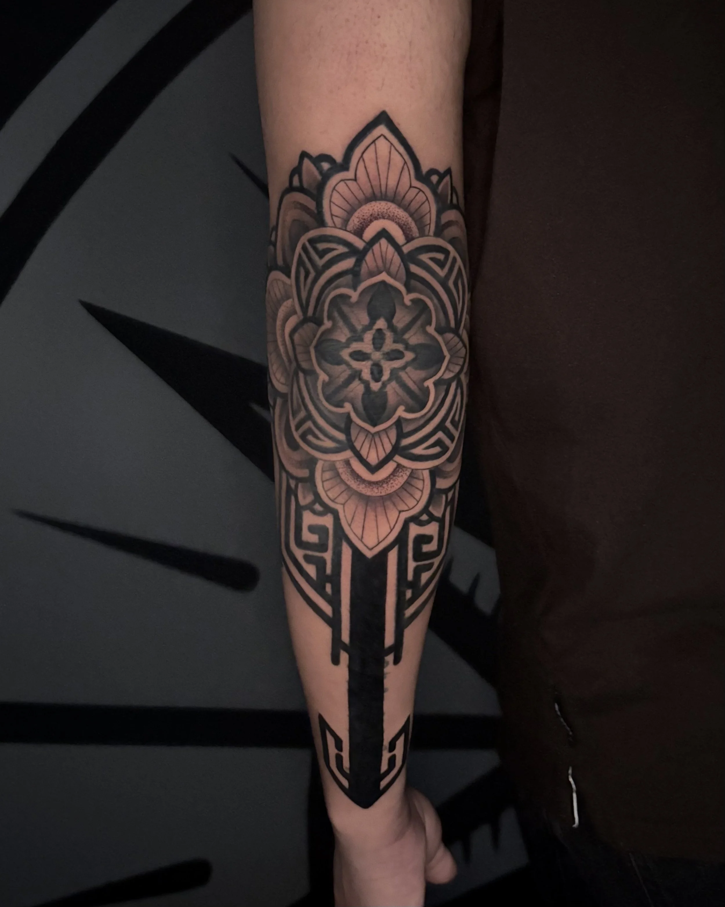 Geometric elbow tattoo by Soleya Tattoo in Auckland — bold blackwork design. A powerful and clean arm piece combining symmetry, mandala, and striking linework.