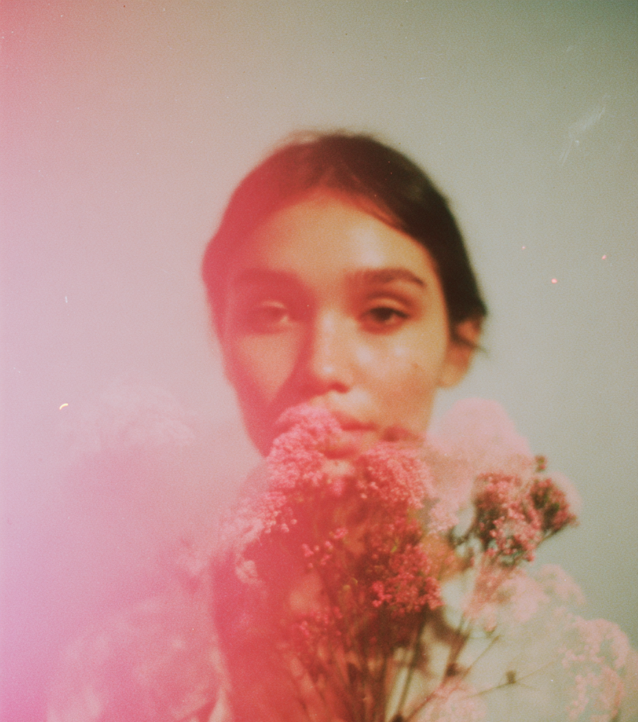 a beautiful woman holding a coral bouquet close to face