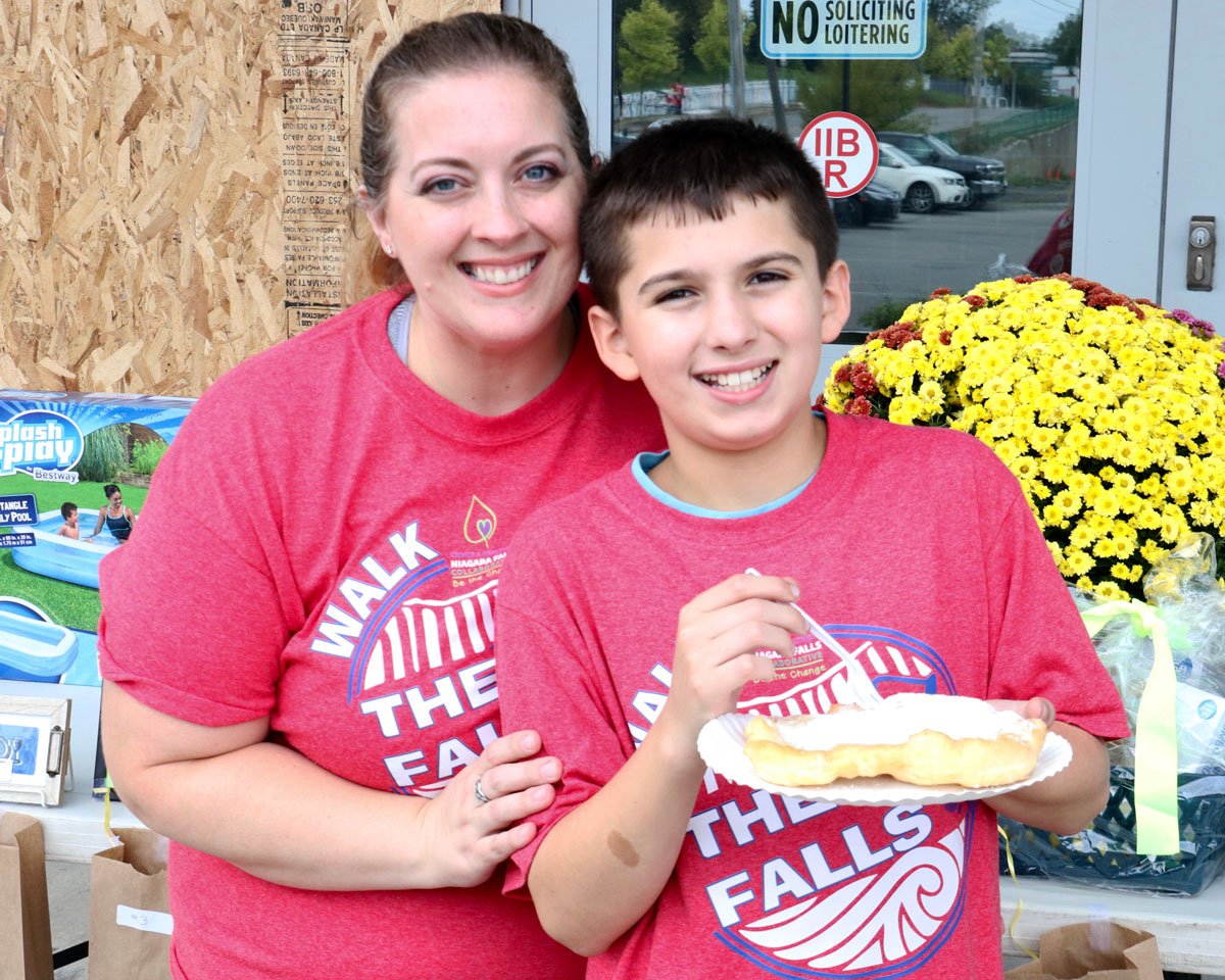 A woman and a boy smiling at the camera.