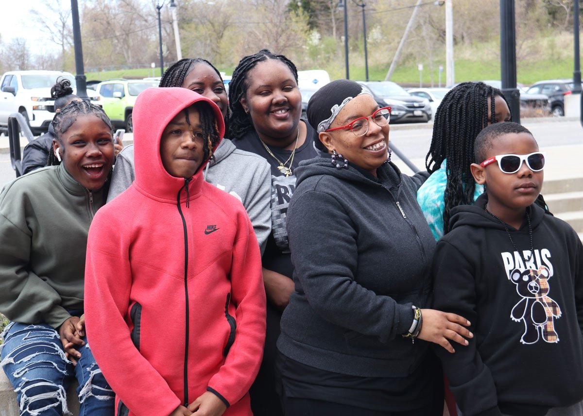 Group of smiling women and children standing outdoors.