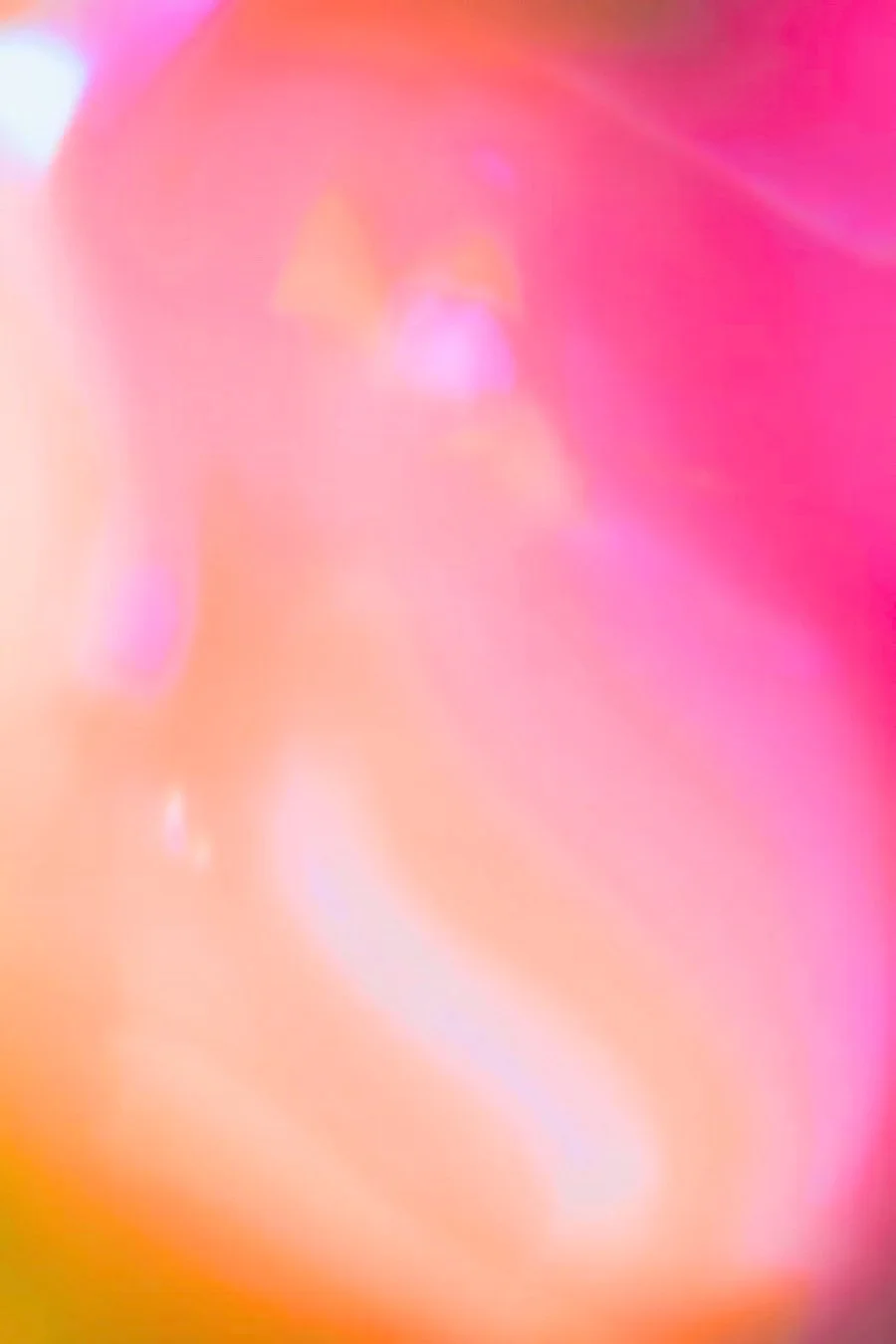 An abstract blur of pink, peach, and yellow colors with no discernible objects.