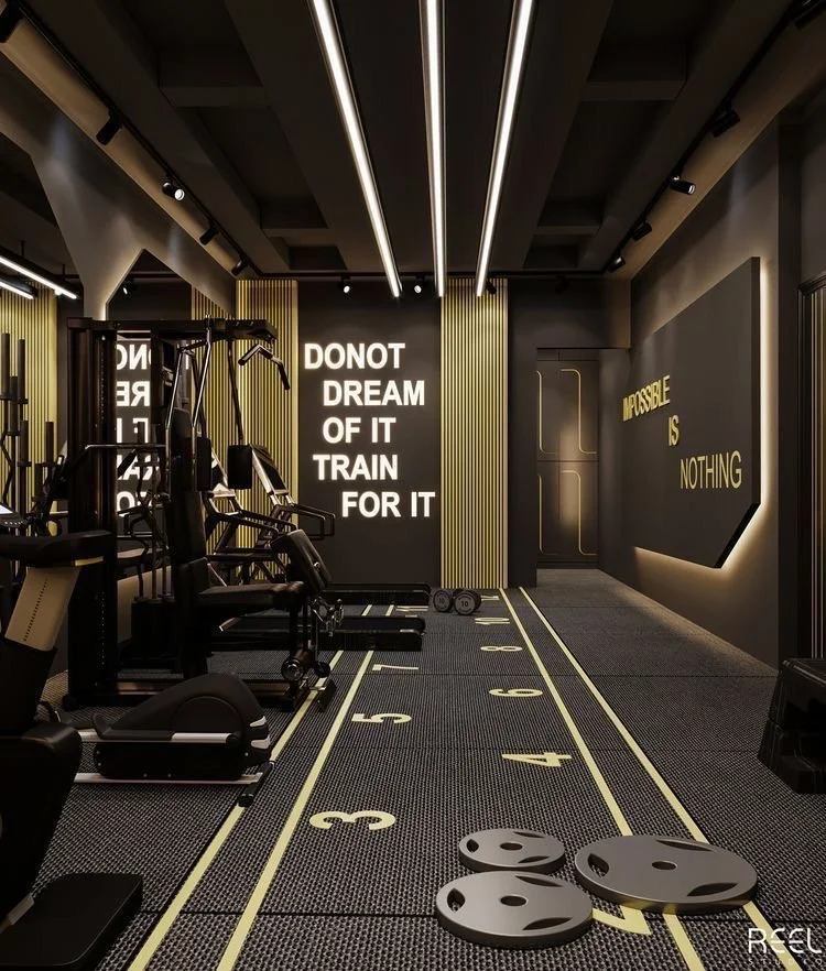 Gym workout area with weightlifting equipment, running track with numbered lanes, motivational wall quotes, and a dark modern interior.