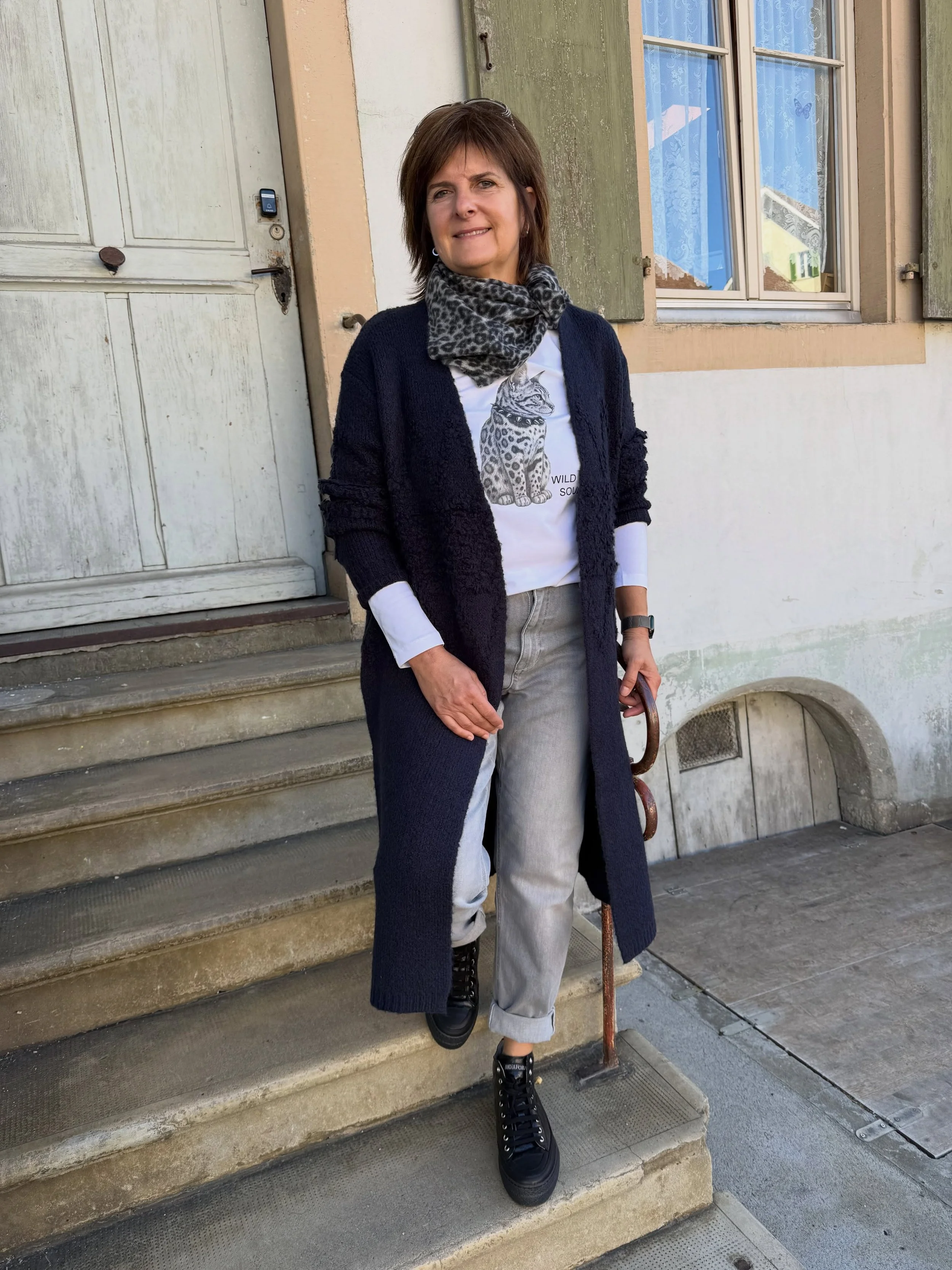 Silbergraue Jeans trifft auf ein Shirt mit modischem Print. Dazu ein edles Cashmere-Nicki-Tuch, ein langer Strickmantel in Marine und kn&ouml;chelhohe Schn&uuml;rschuhe.

Ein sportlich- l&auml;ssiger Herbstlook mit stilvollen Details.  Unkompliziert,