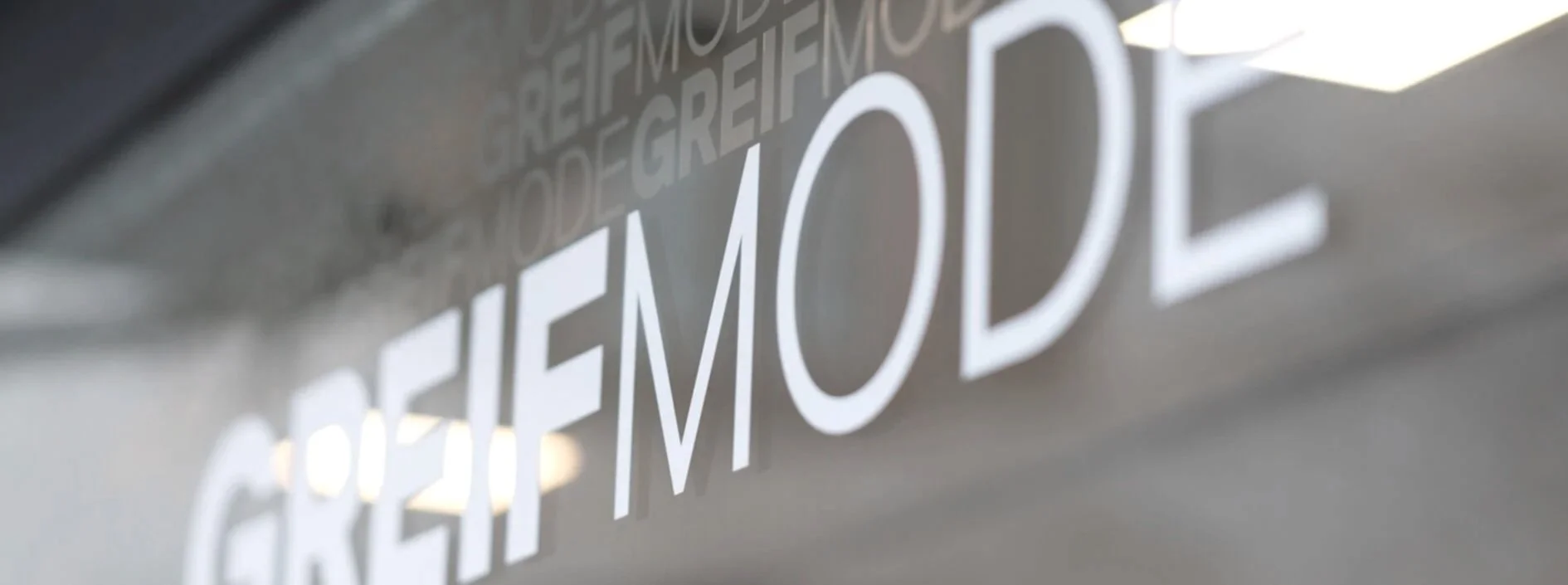 Nahaufnahme der Fensterfront vom Modegeschäft Greif-Mode.