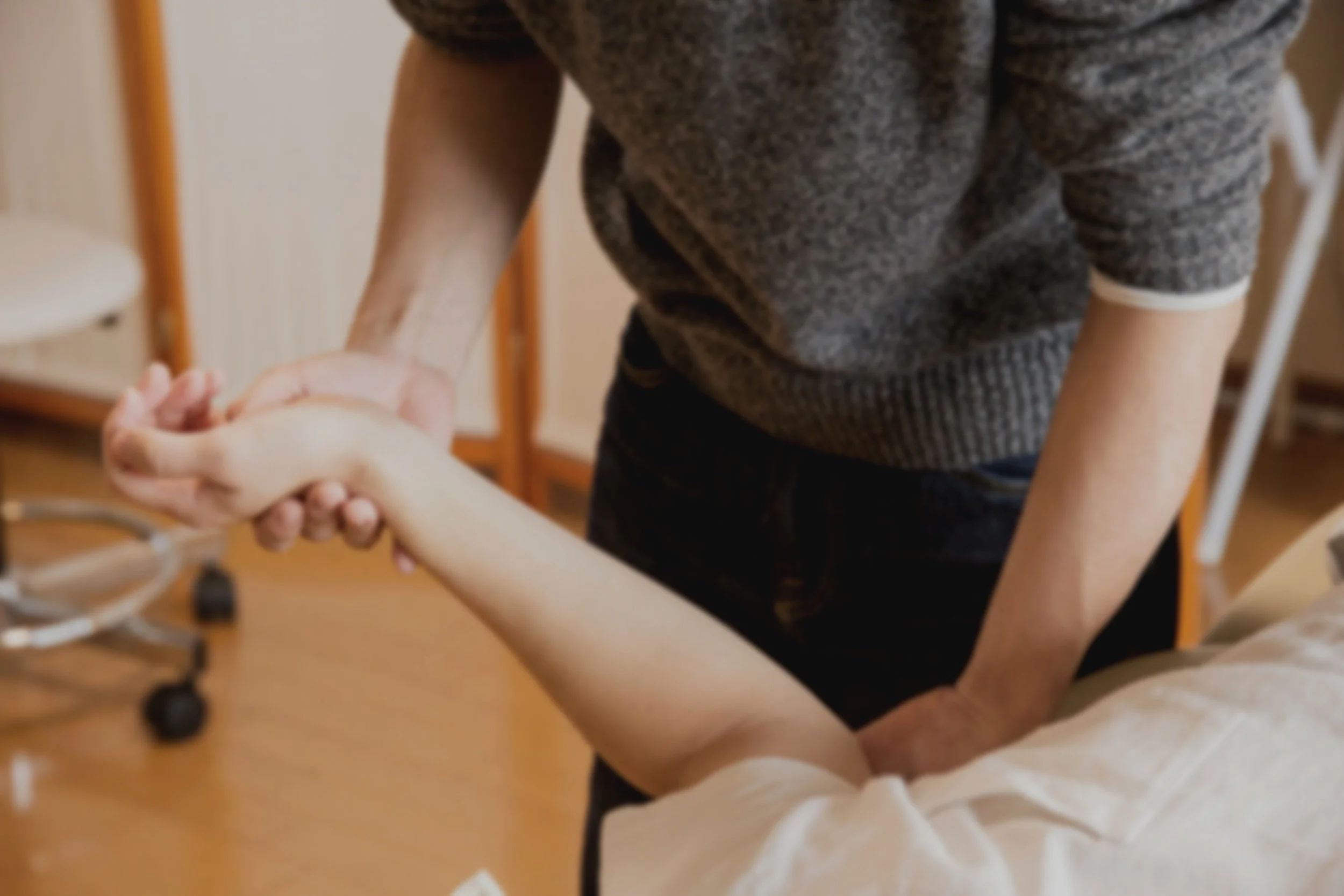 A person physical therapist stretching a patient's arm during therapy session.