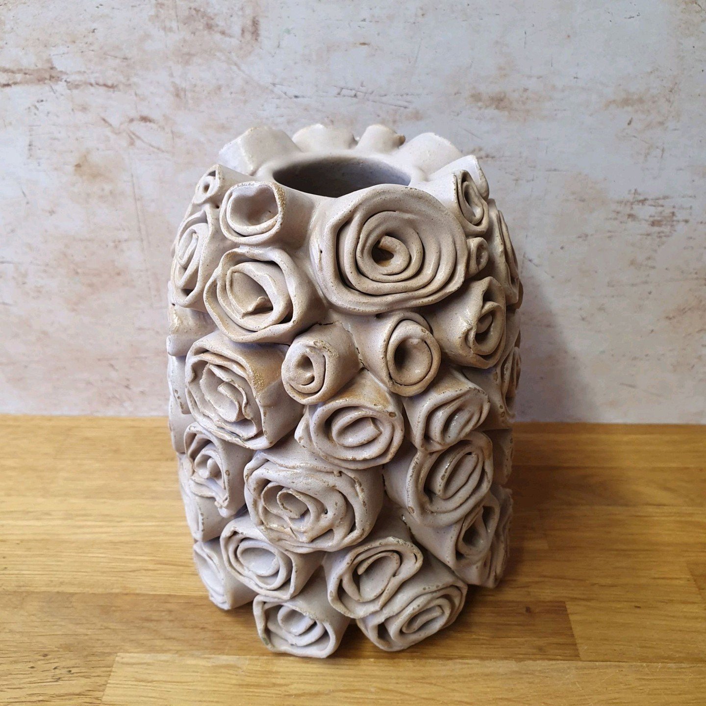 Muted, shabby roses bloom elegantly from this handbuilt vase, evoking gentle whispers of timeless beauty. 🌸 Crafted with care and creativity, it's more than decor; it tells a story of art and nature intertwined. 

Where would you place such a lovely