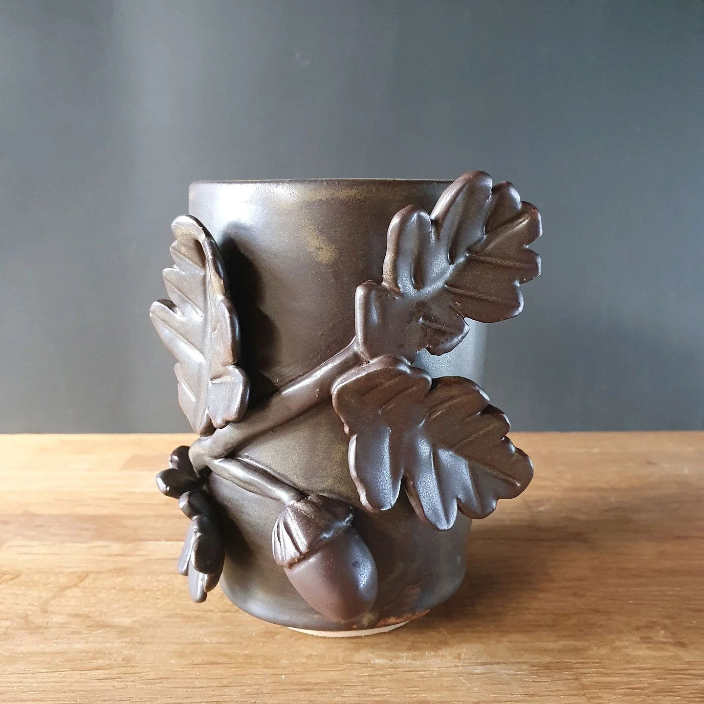 Learning to throw 
I made the cylinder and then I thought what should I do with it so I put some oak leaves and acorns on it and I wish I'd put hole in the bottom because it would have made it perfect toothbrush holder

#PotteryLove
#RusticPottery
#H