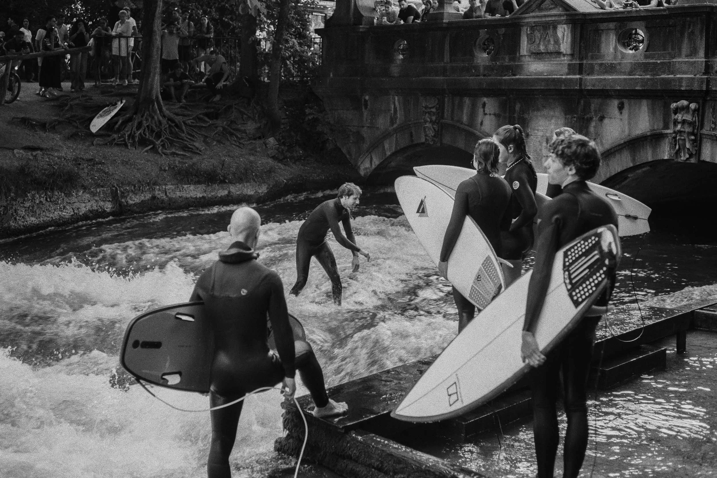 Surfer warten mit ihren Boards auf die nächste Welle.