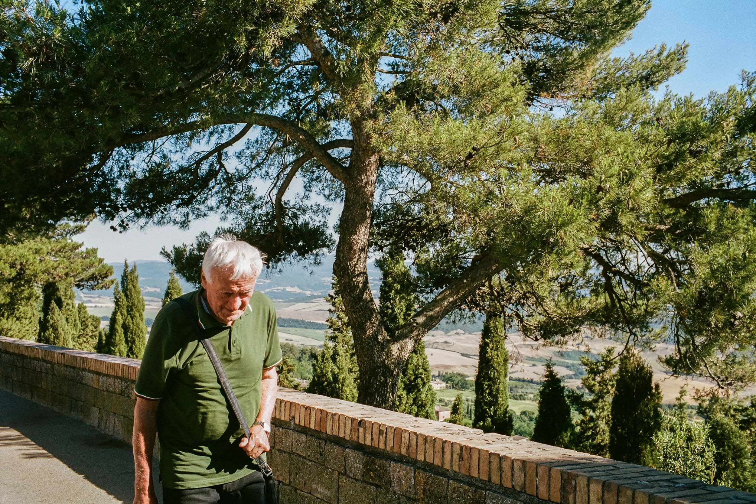Spaziergänger in Volterra mit Blick über die Landschaft der Toskana.