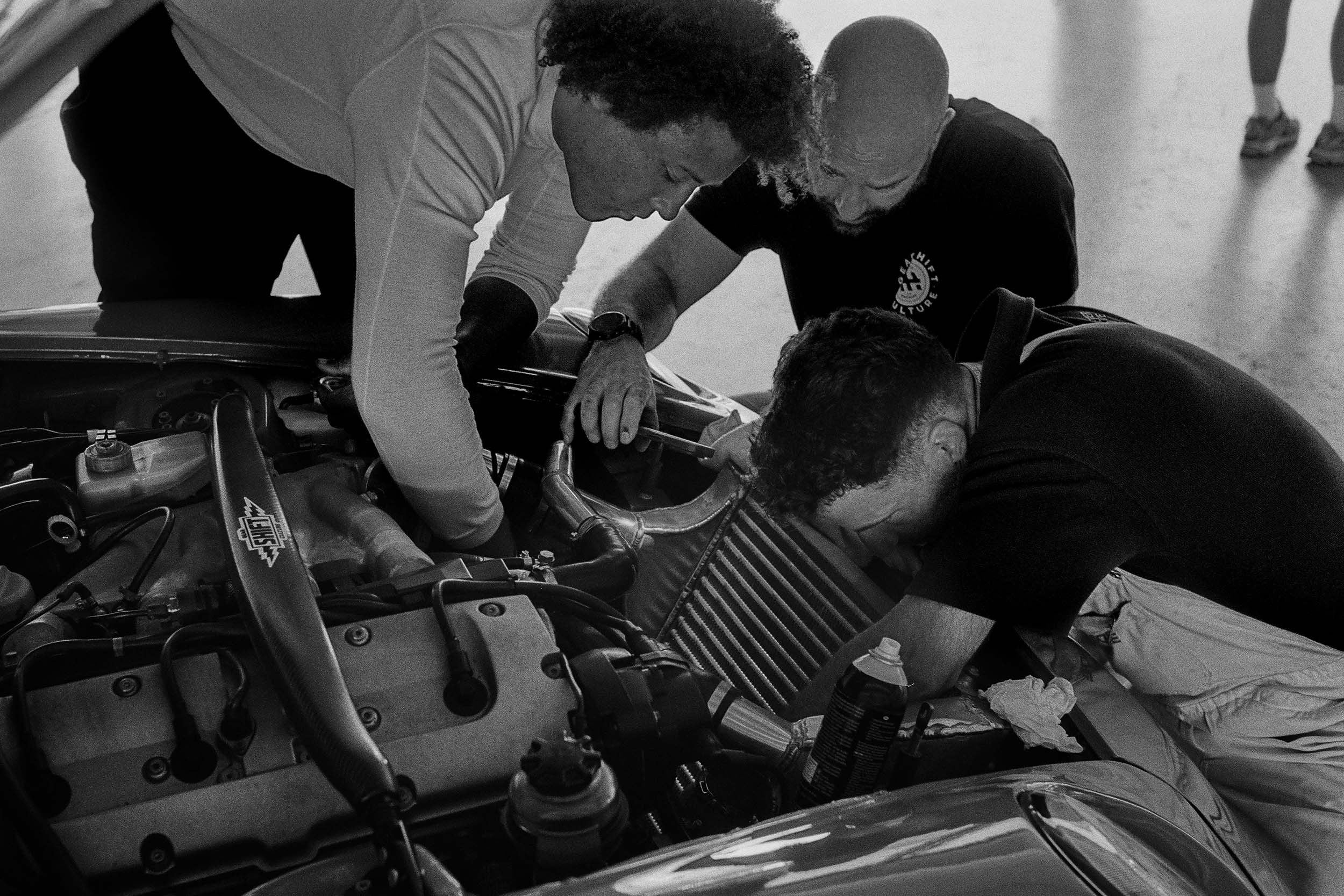 Mechaniker arbeiten am Motor eines klassischen Porsche.