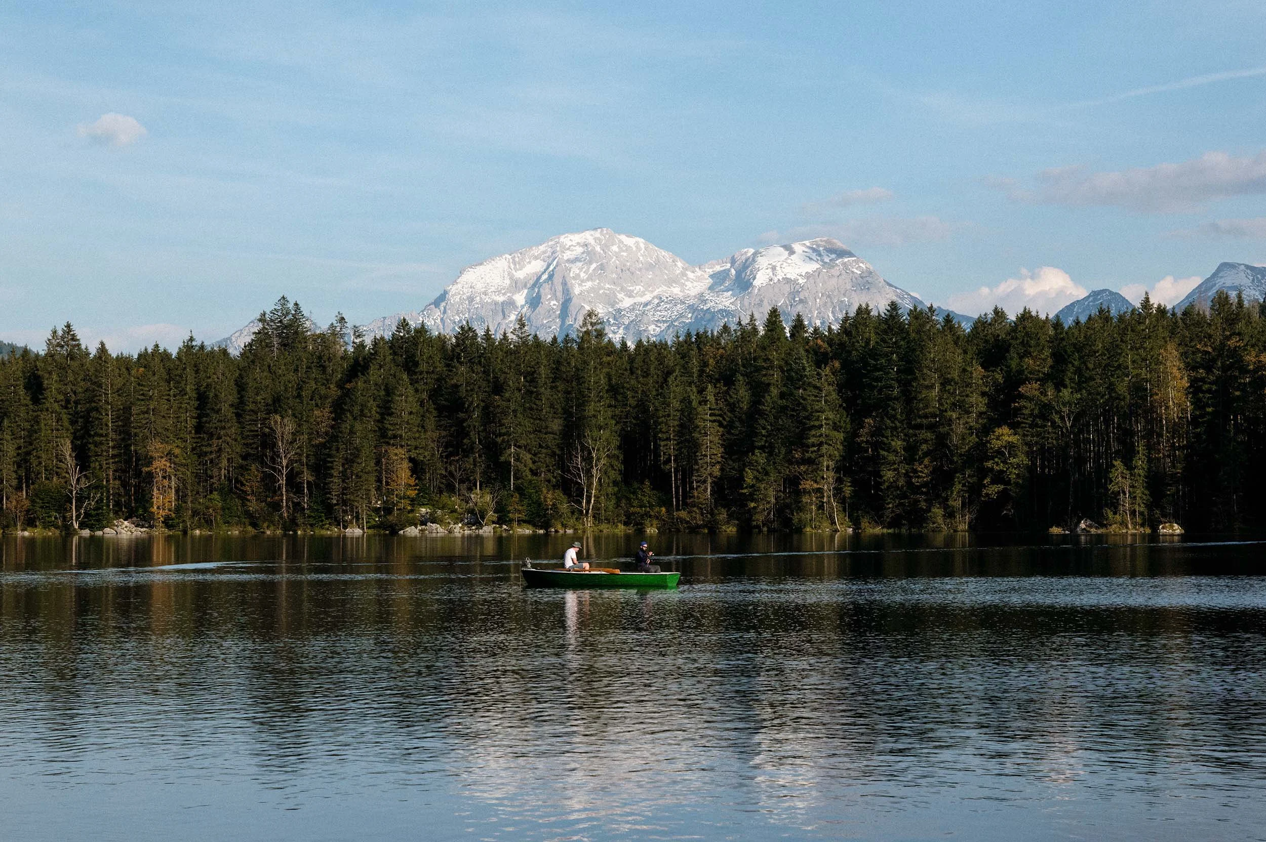 Zwei Personen im Boot auf See in Berchtesgaden vor Nadelwald und Alpenpanorama