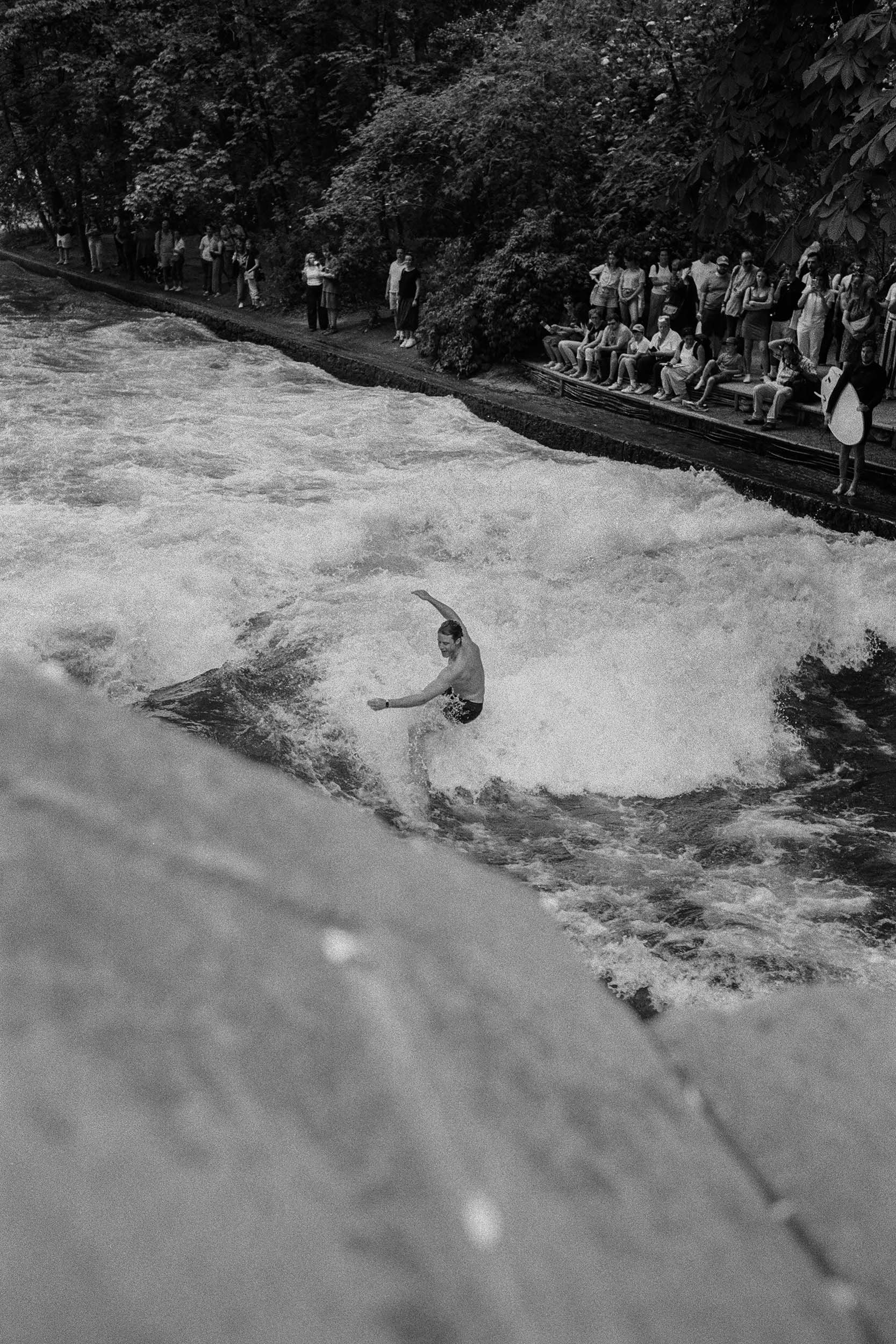 Zuschauer verfolgen das Surfen an der Eisbachwelle.
