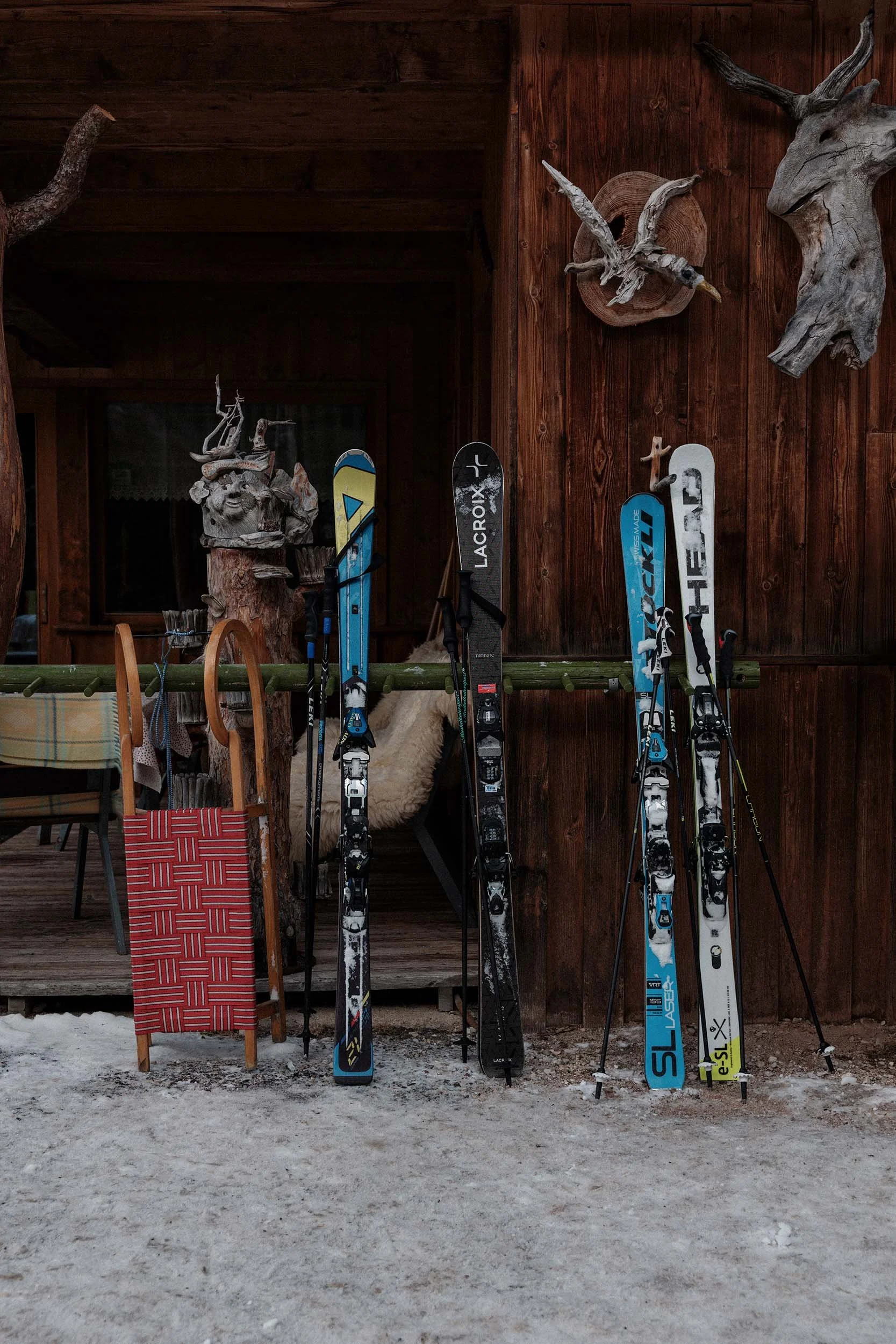 Skier vor rustikaler Holzhütte in den Dolomiten