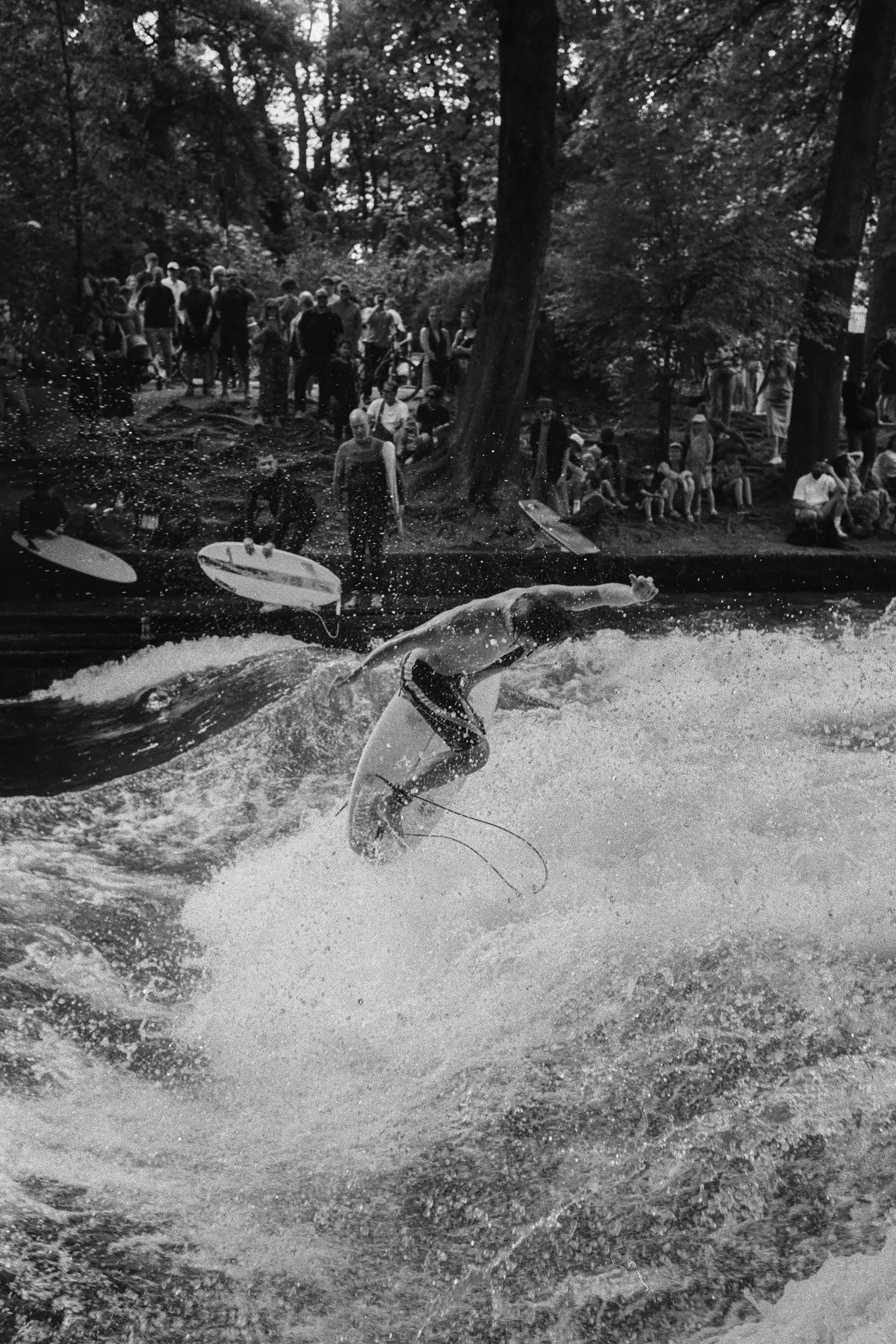 Surfer bei einem Sprung auf der Eisbachwelle in München.