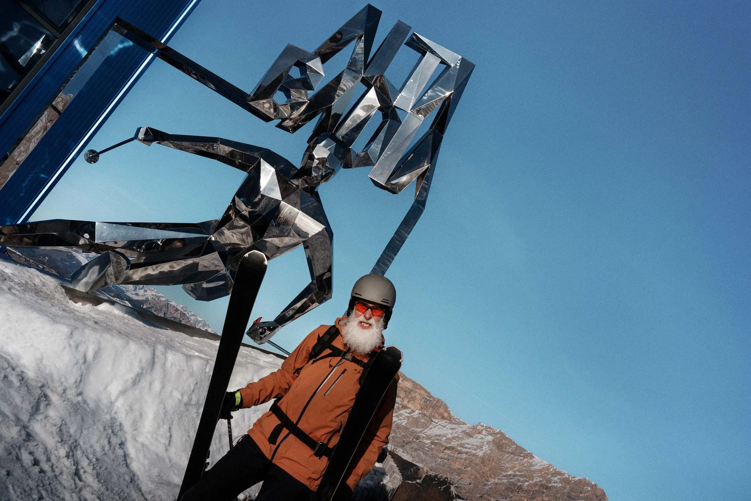 Skifahrer vor moderner Skulptur in Alta Badia mit Bergkulisse