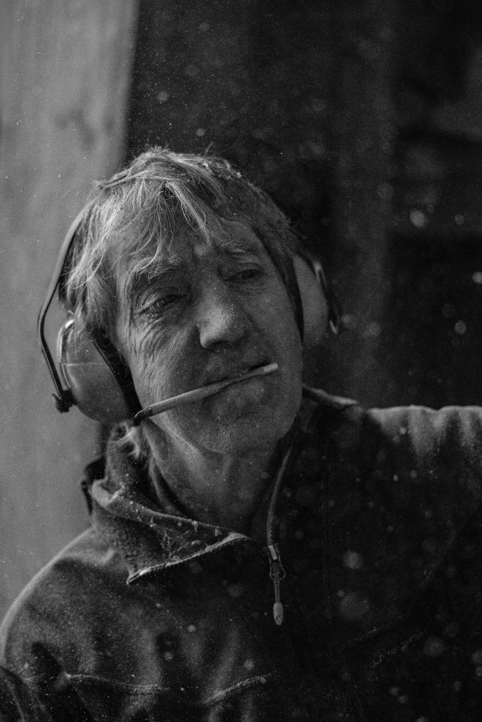 Portait von Ernst Groß bei Arbeit an Holzskulptur in Werkstatt