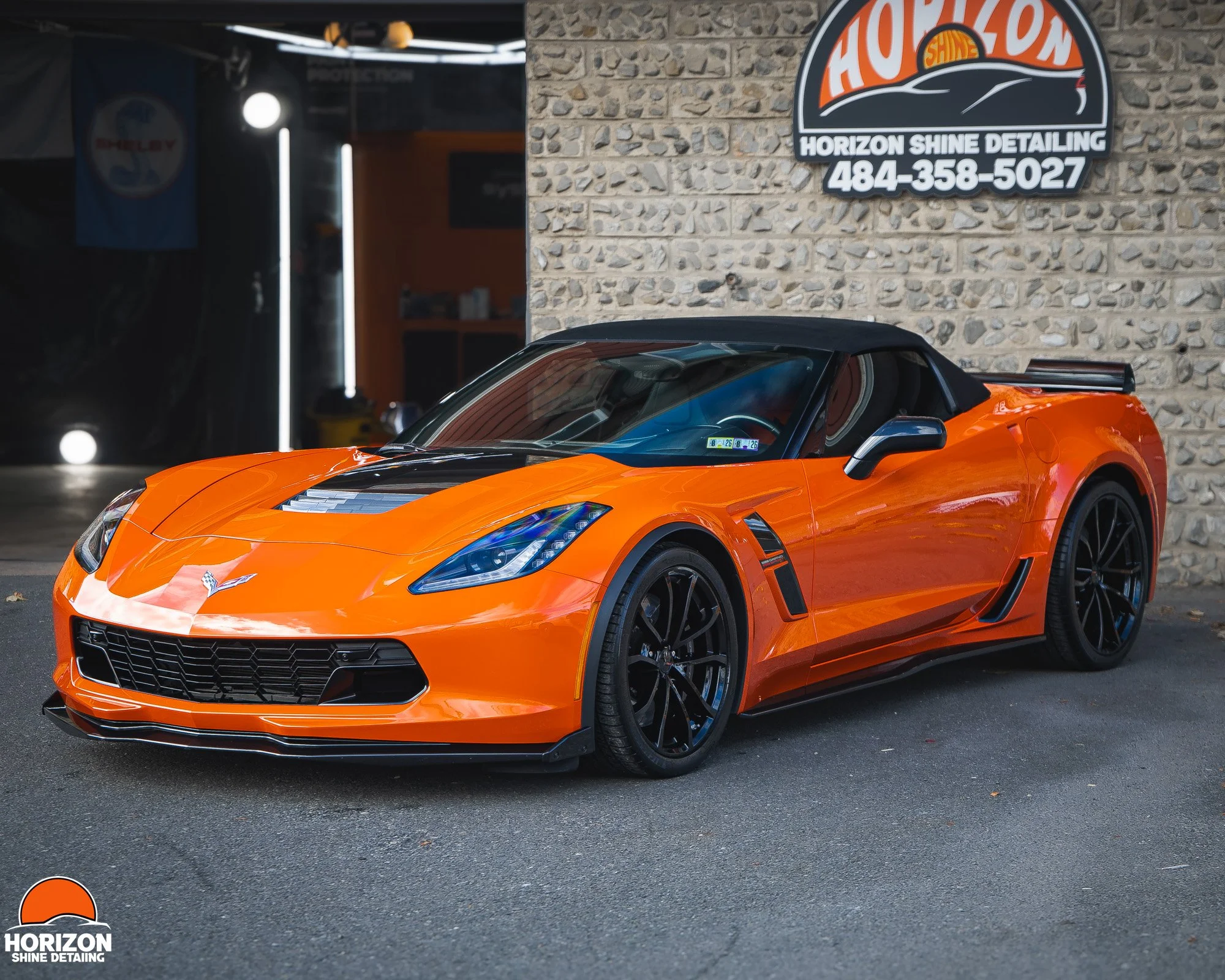 orange corvette parked in front of horizon shine detailing shop