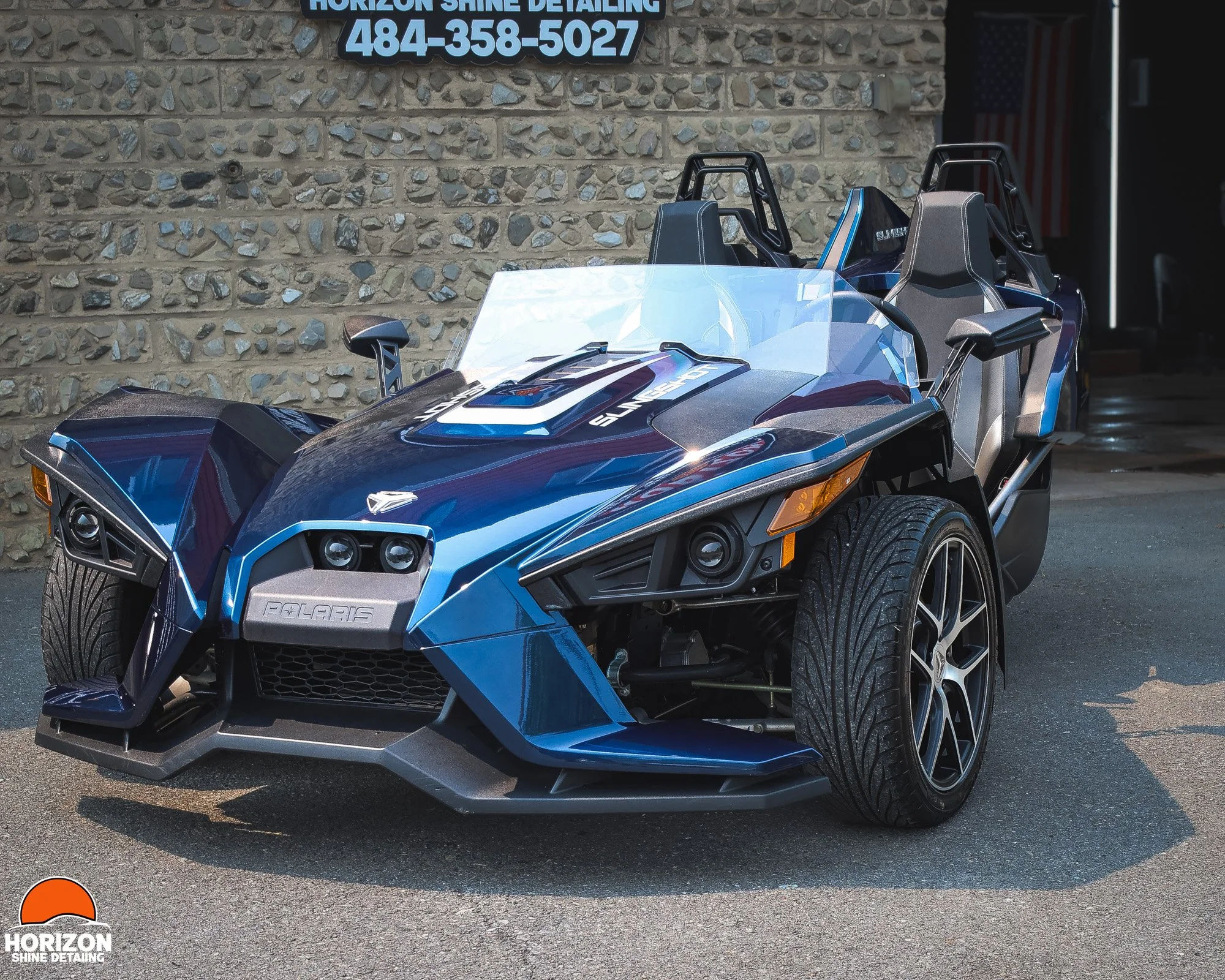 Blue Polaris Slingshot parked in front of of horizon shine detailing