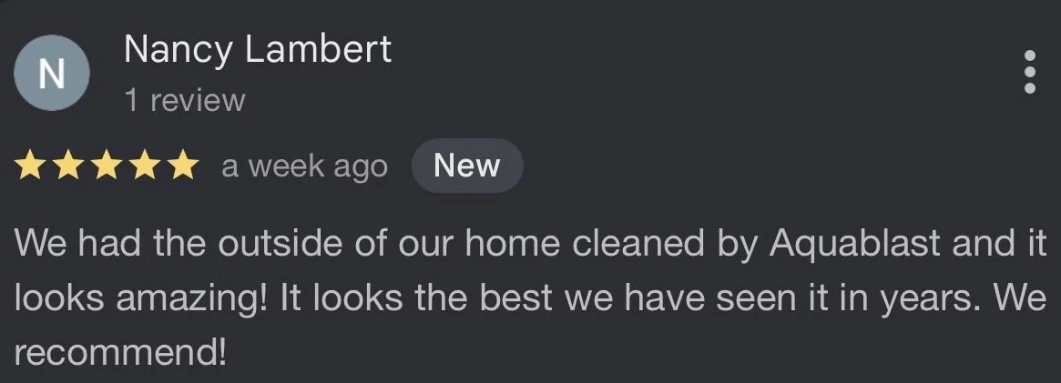 Screenshot of a Google review, with five gold stars, written by Nancy Lambert, praising Aquablast for cleaning the outside of her home.
