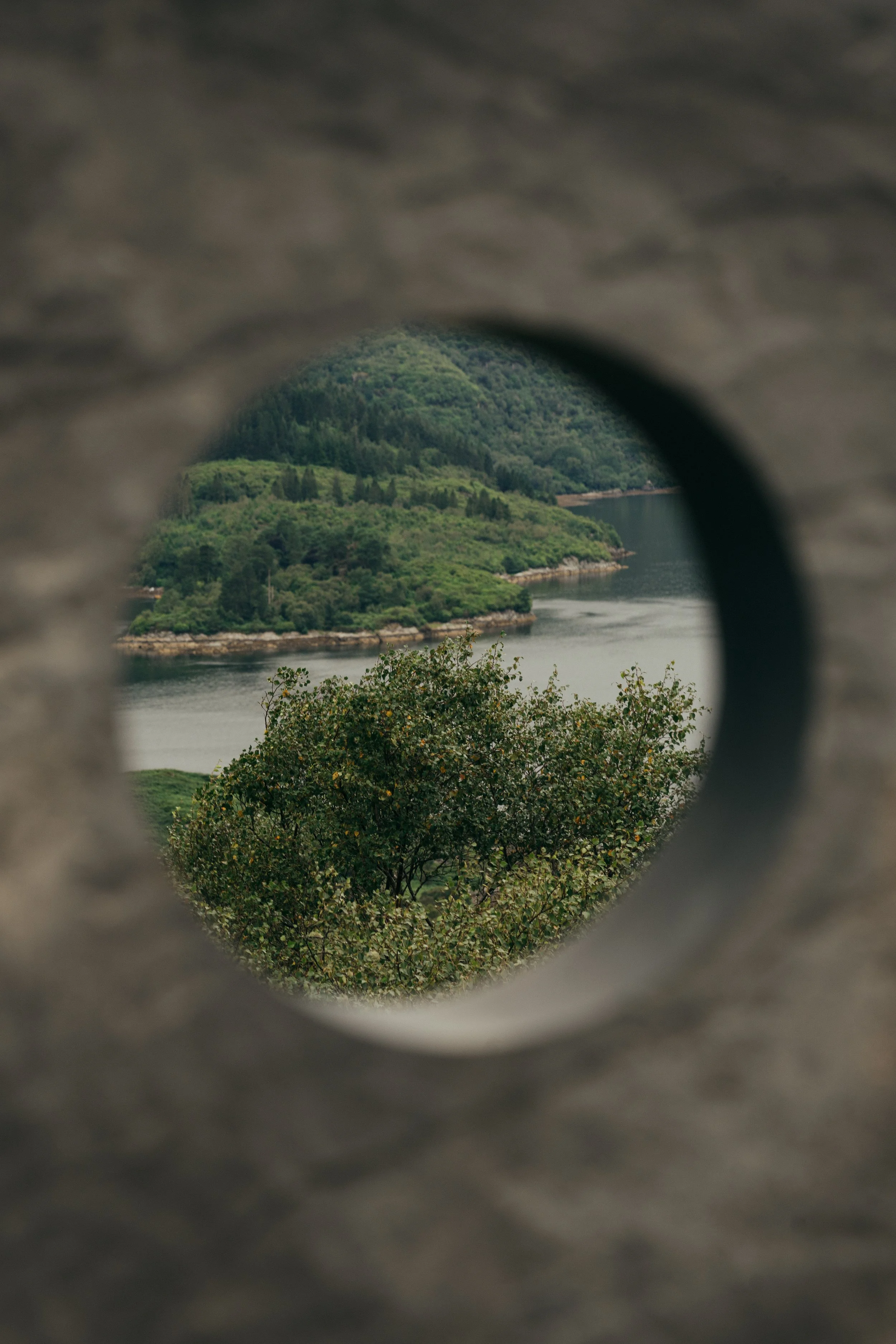 Looking through a stone circle, a view of scottish water and greenery
