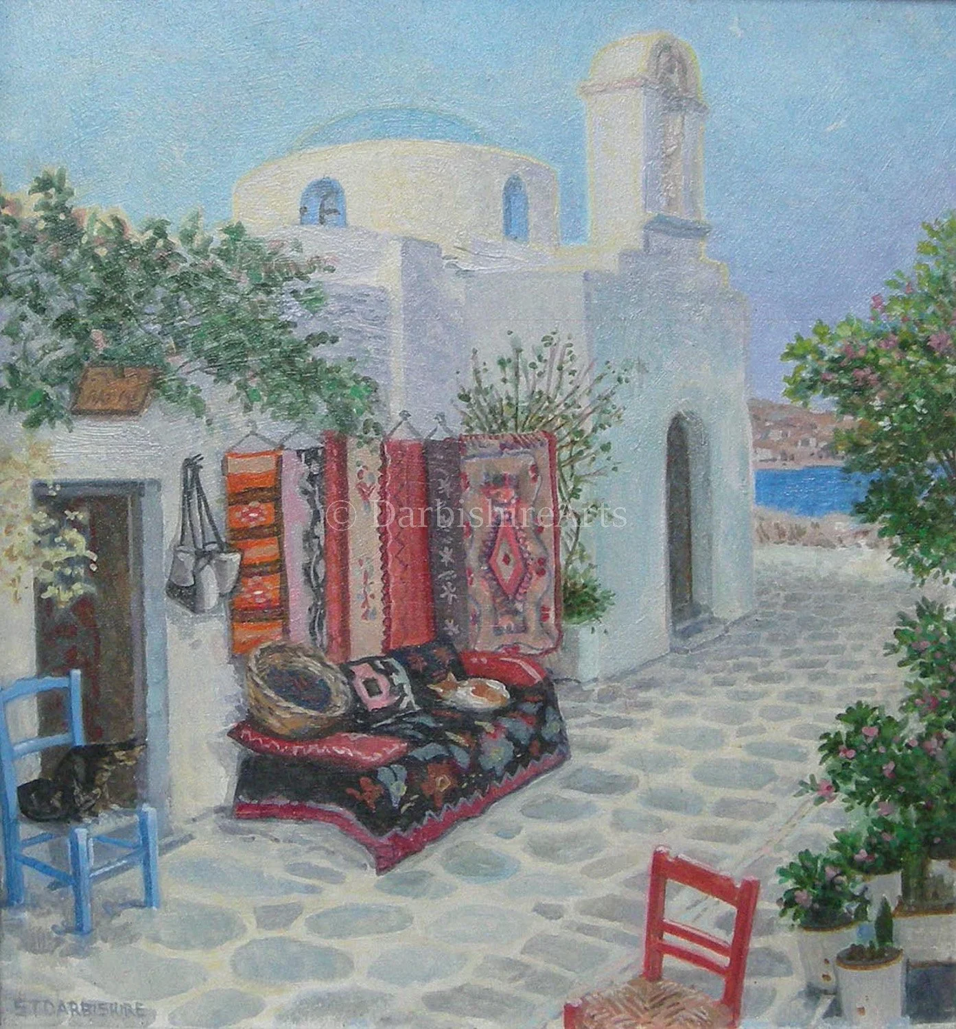 Painting of a white building with a domed roof and a bell tower, decorated with hanging rugs and cushions, surrounded by potted plants and colorful chairs on a cobblestone patio overlooking the sea.