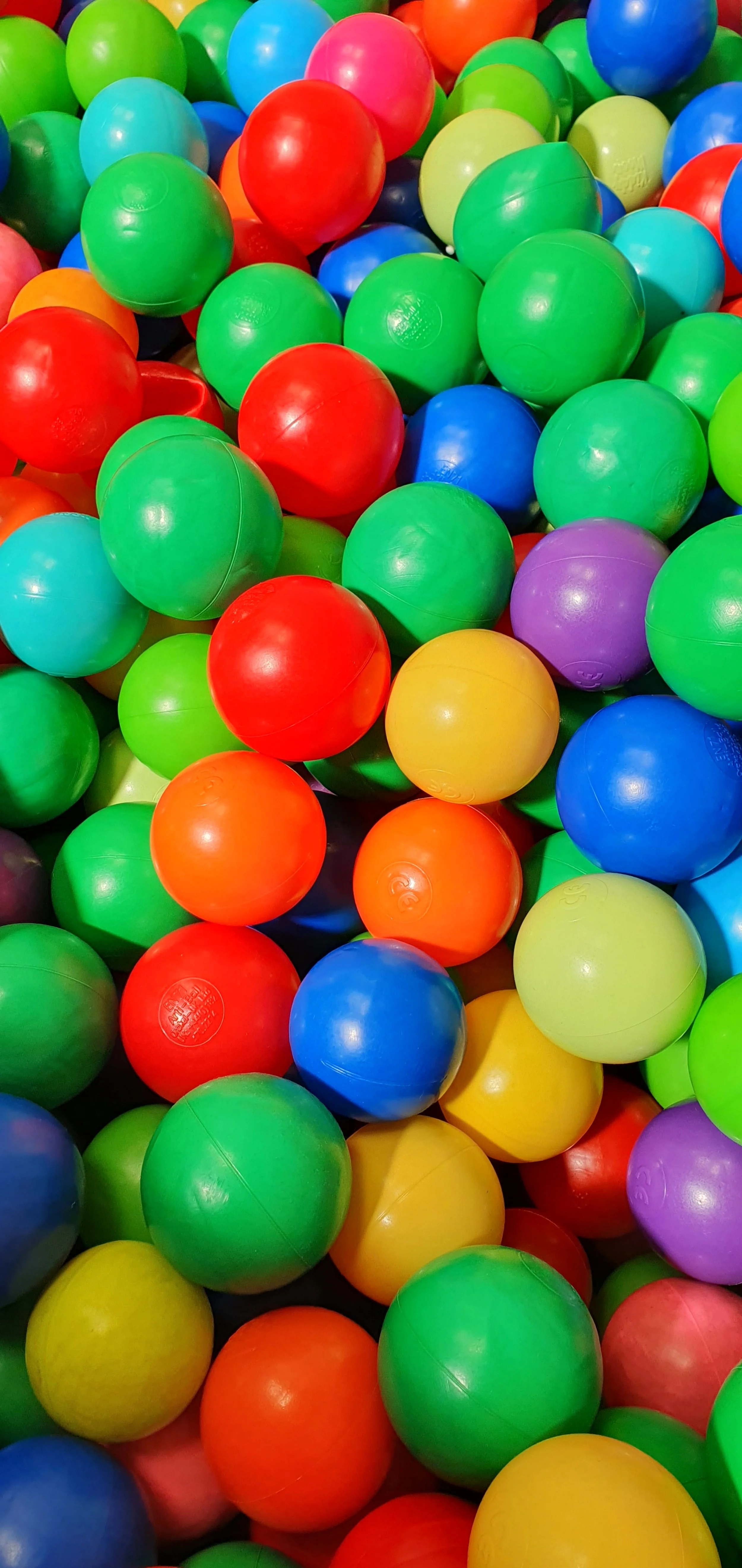 A colorful collection of plastic balls in red, green, blue, yellow, purple, orange, and teal.