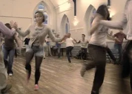People dancing in a church hall.