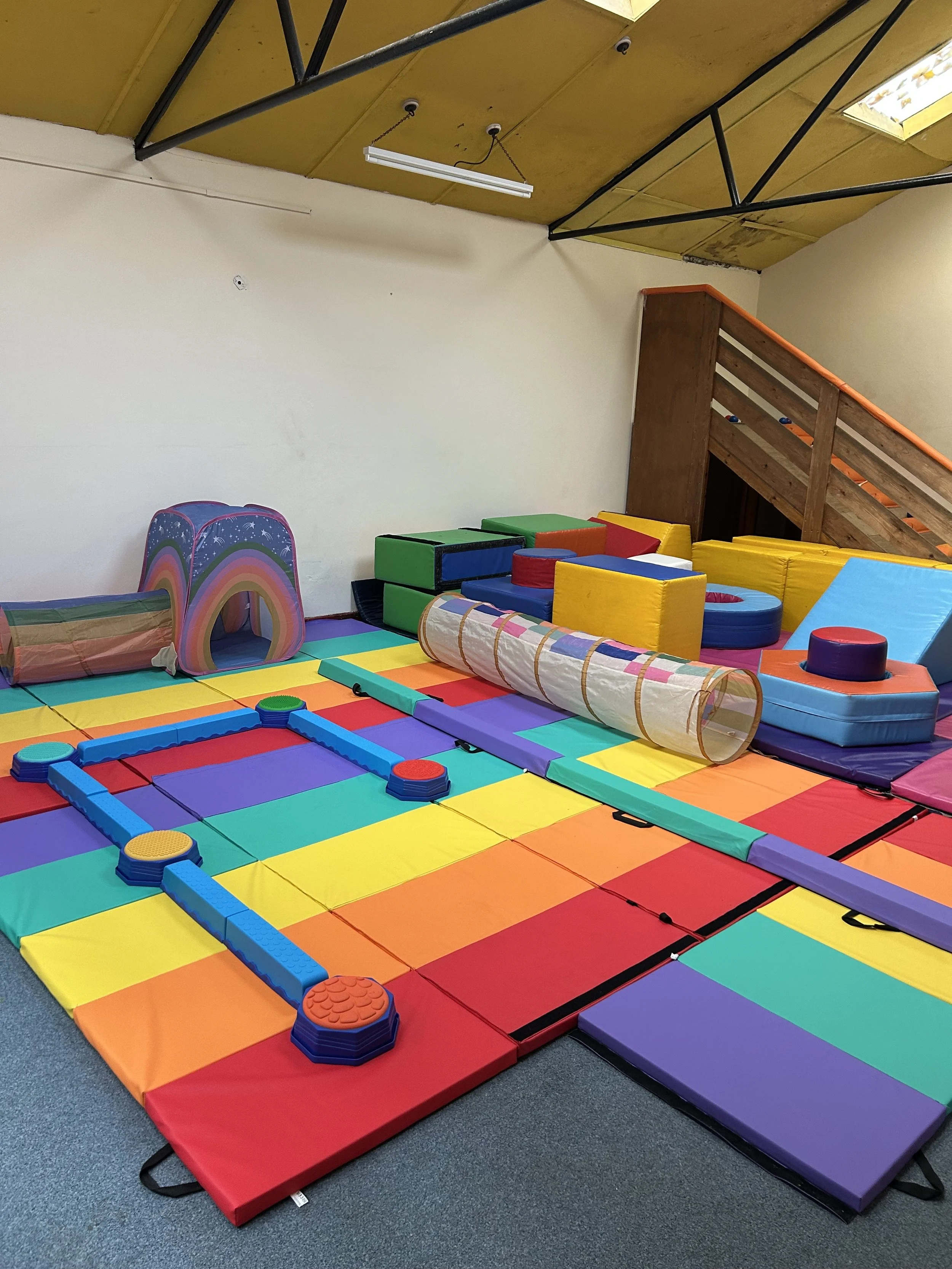 Colourful indoor play area with foam mats, soft blocks, and tunnels for children to hire for parties in Bristol