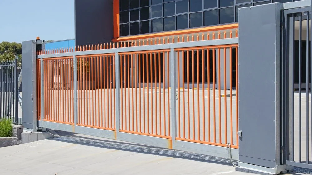 Orange and gray metal sliding gate in front of a commercial building