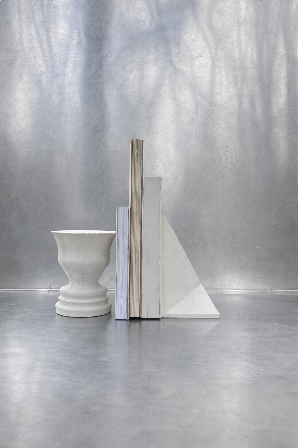 White concrete and ceramic objects arranged with books