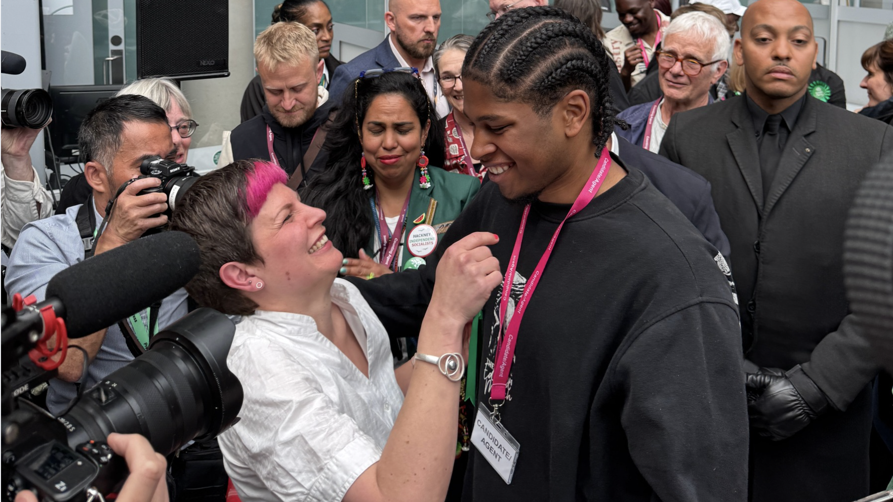 A man and woman hug in a coded place with cameras