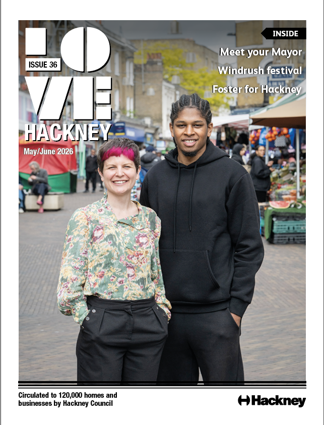 A man and woman stand side by side outside a market