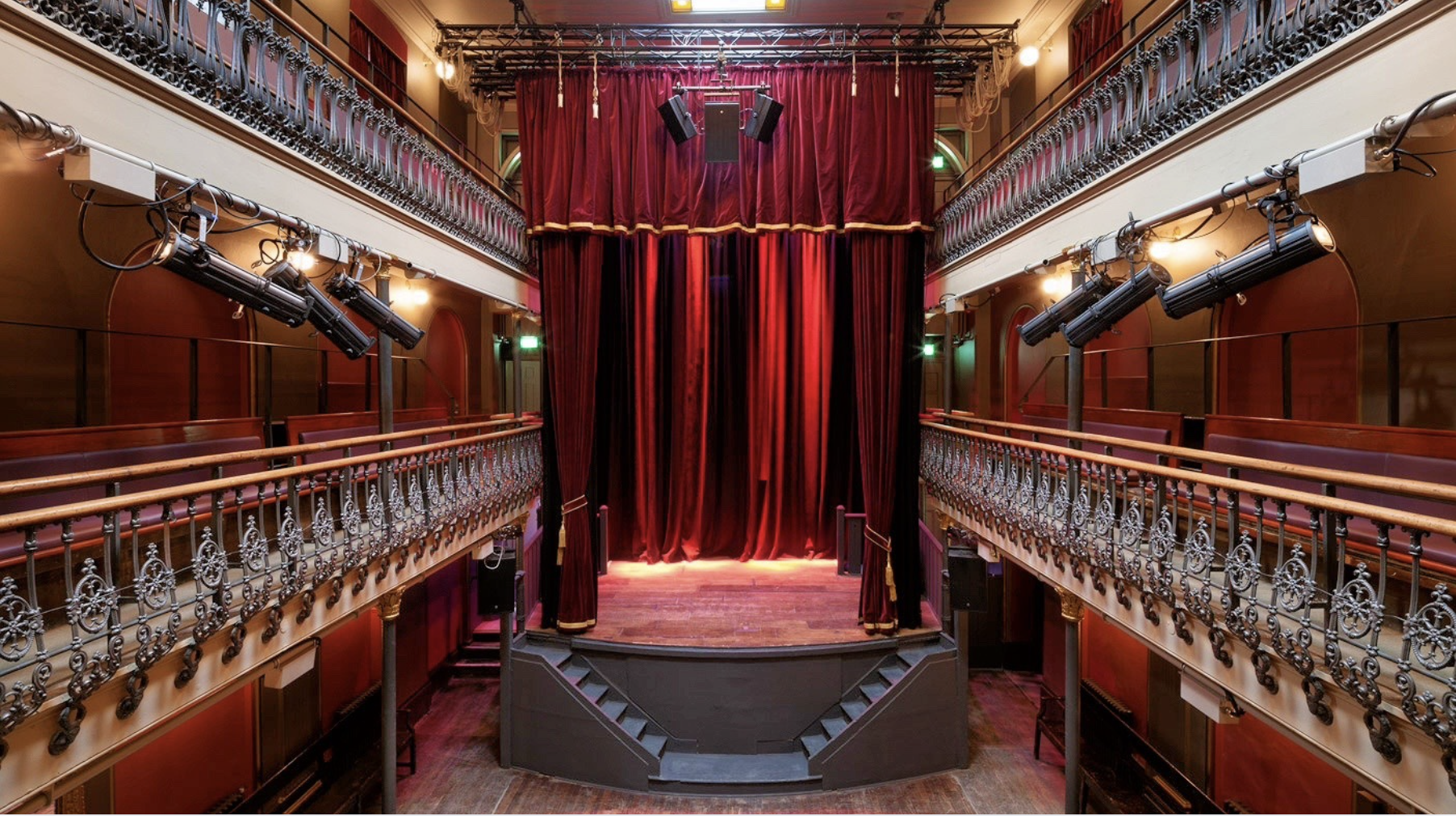 the inside of a theatre with a red velvet curtain