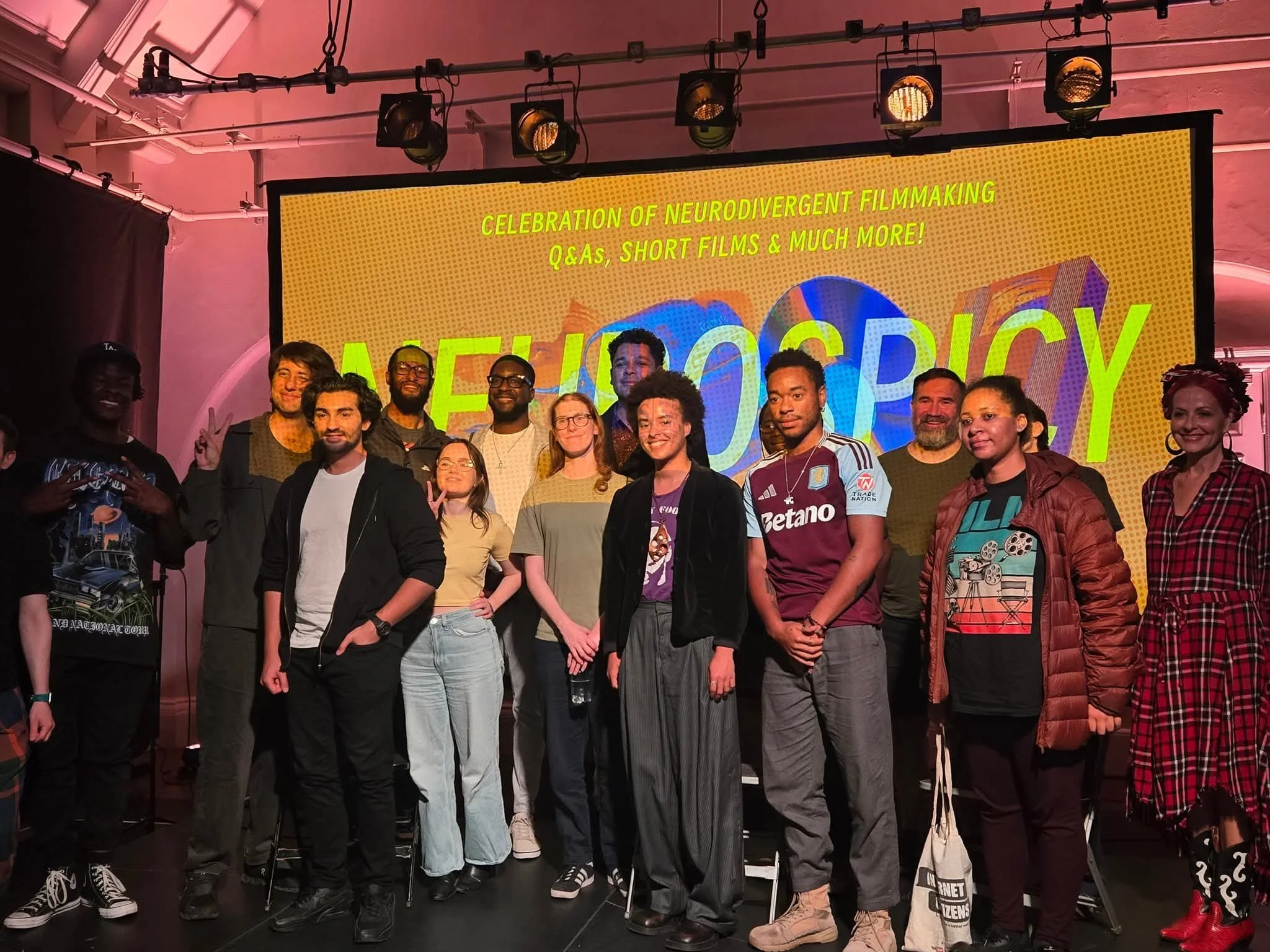 A group of people standing in front of a large screen.