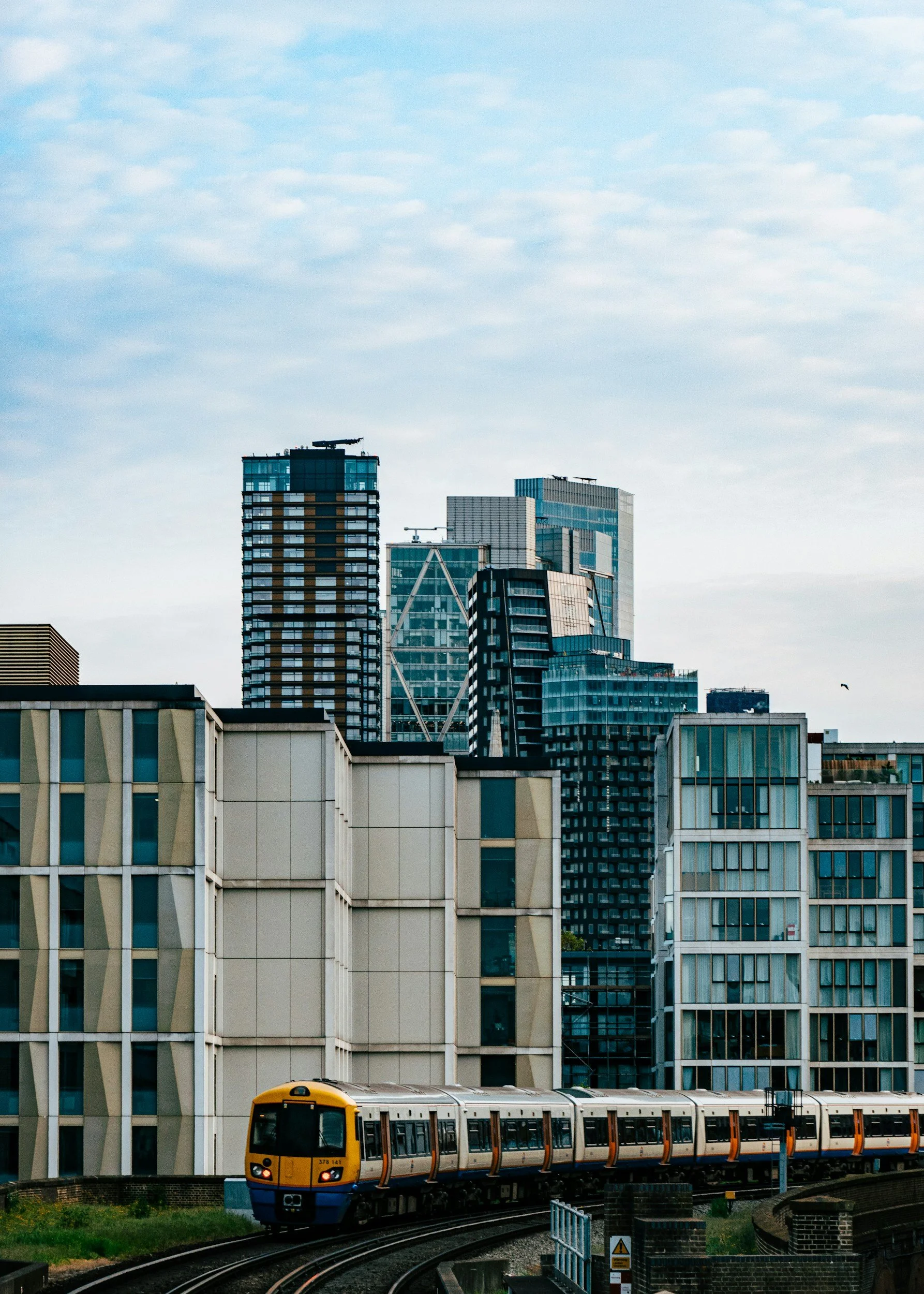 A view of the city from Hoxton Street, featuring tower blocks and a train on a high level track winding its way at the foreground of the image