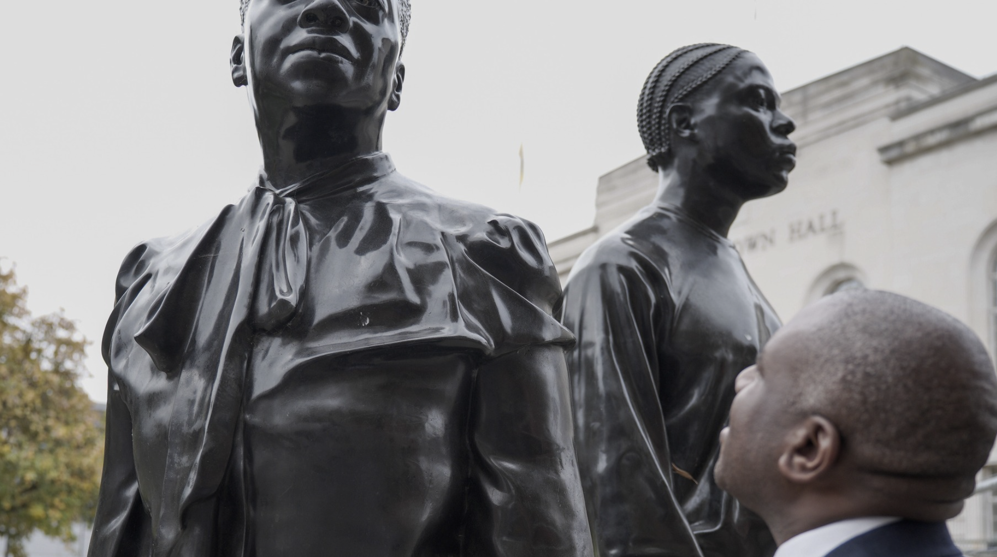 David Lammy MP looks up at Hackney's Windrush sculpture by Thomas J Price