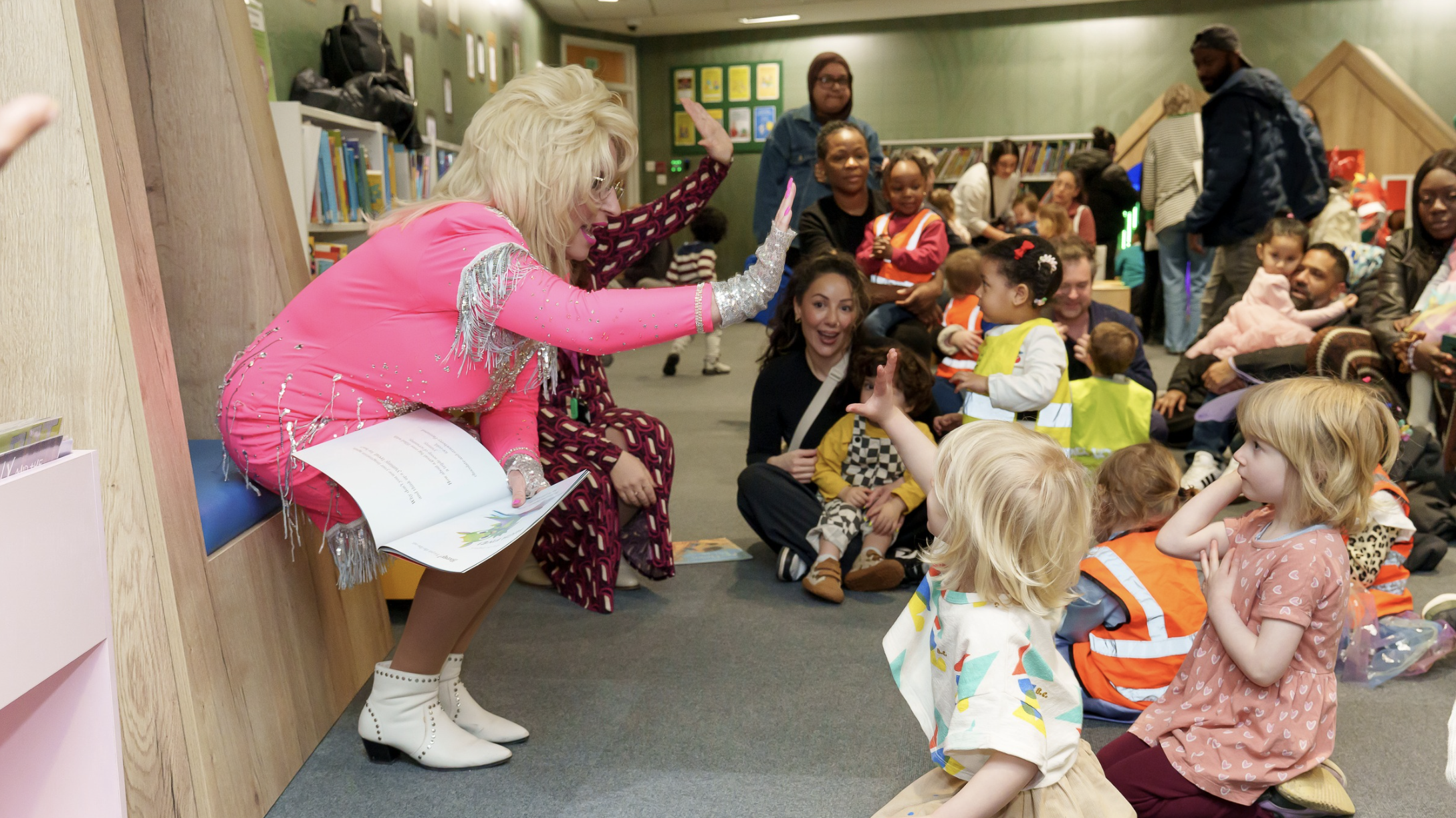 A Dolly Parton lookalike high-fives children