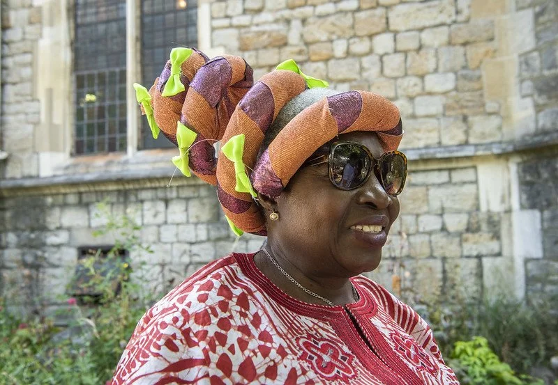 Image of a woman with sunglasses and an elaborate spiral hat
